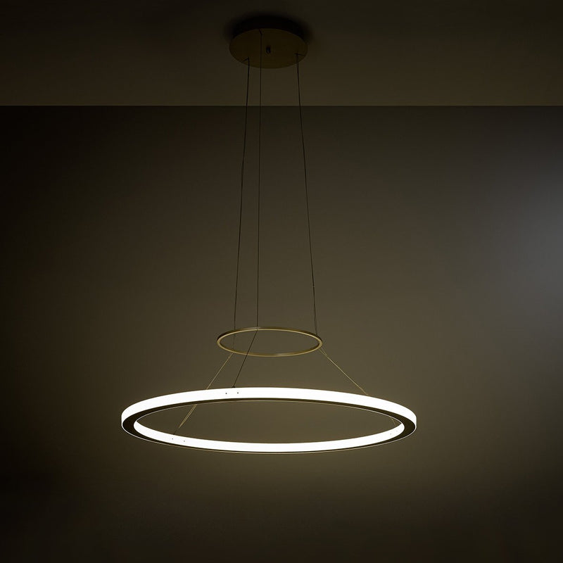 The KAIA RIO In and Out Suspension features two circular LED rings suspended elegantly, with the larger ring illuminated for a striking contrast, while the smaller unlit ring enhances the modern designs depth and intrigue.