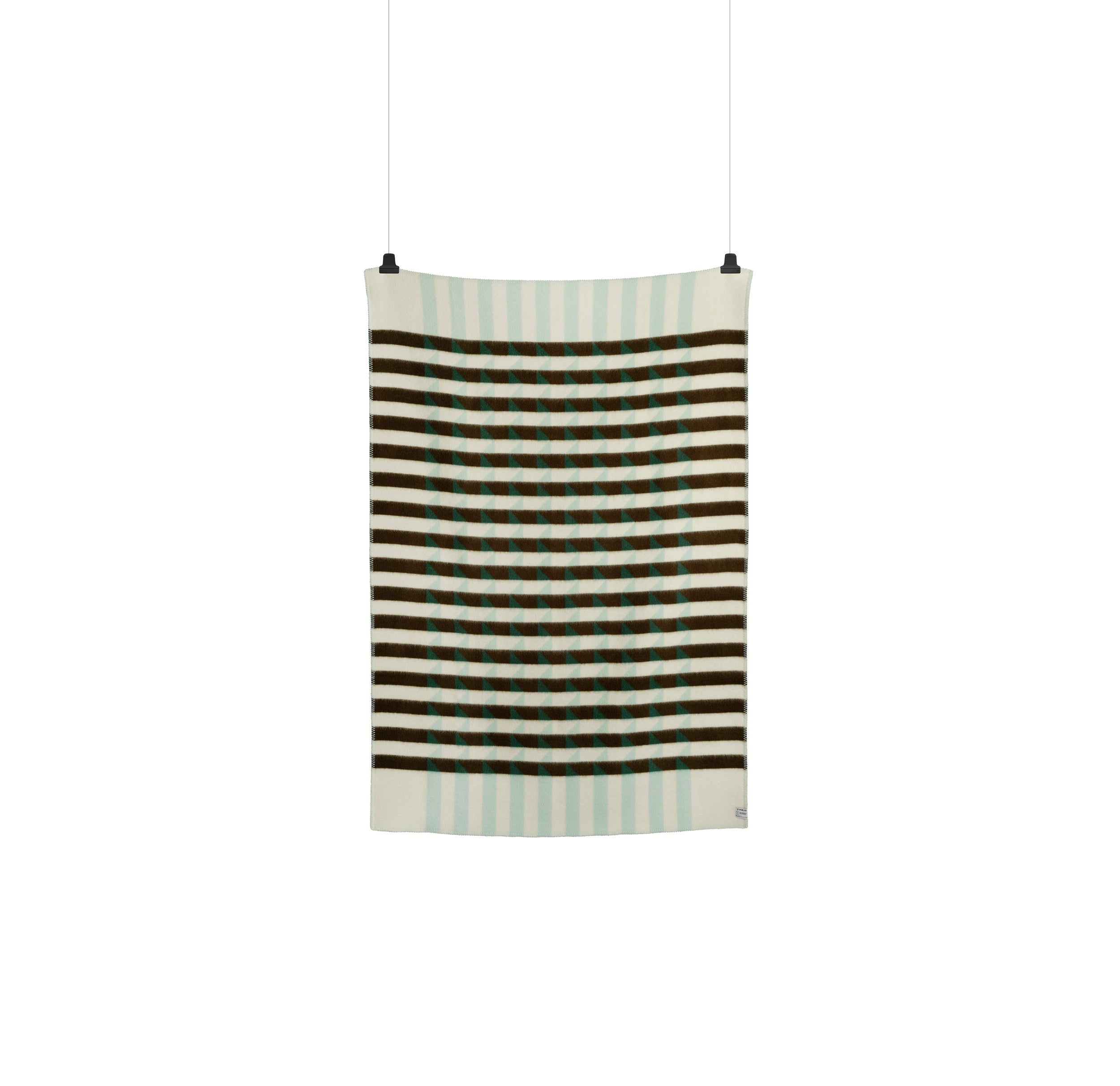 The Kvam Large Throw by Roros is a vertically hanging textile made from Norwegian lambswool, showcasing a geometric design with brown and white horizontal stripes and light blue grid squares. Its designed to create an optical illusion effect and is suspended by two top clips.