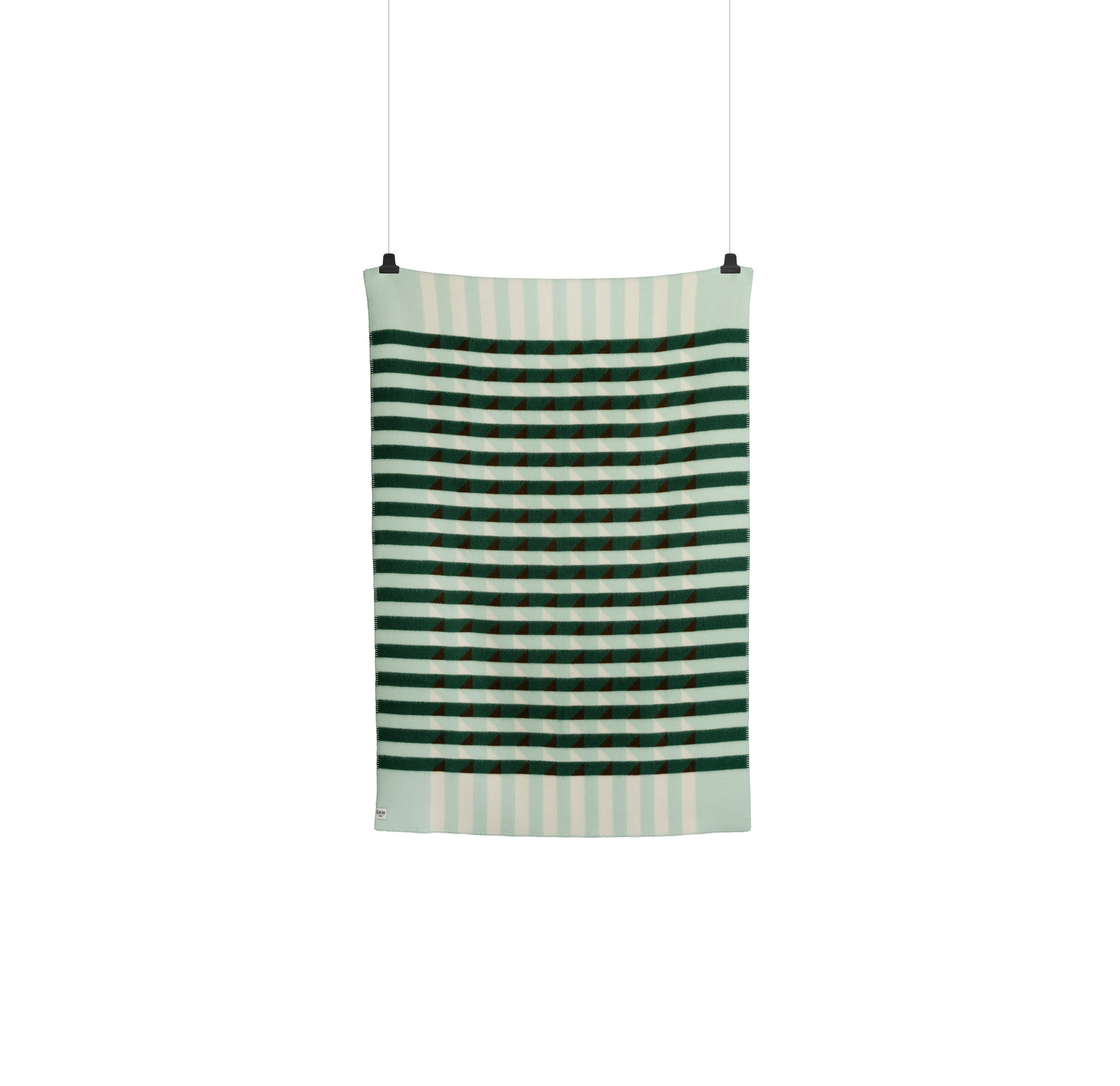 The Kvam Large Throw by Roros is a hanging blanket made from luxurious Norwegian lambswool. It features green and white stripes with dark green and rust rectangles forming a checkerboard pattern, and its suspended by two clips.