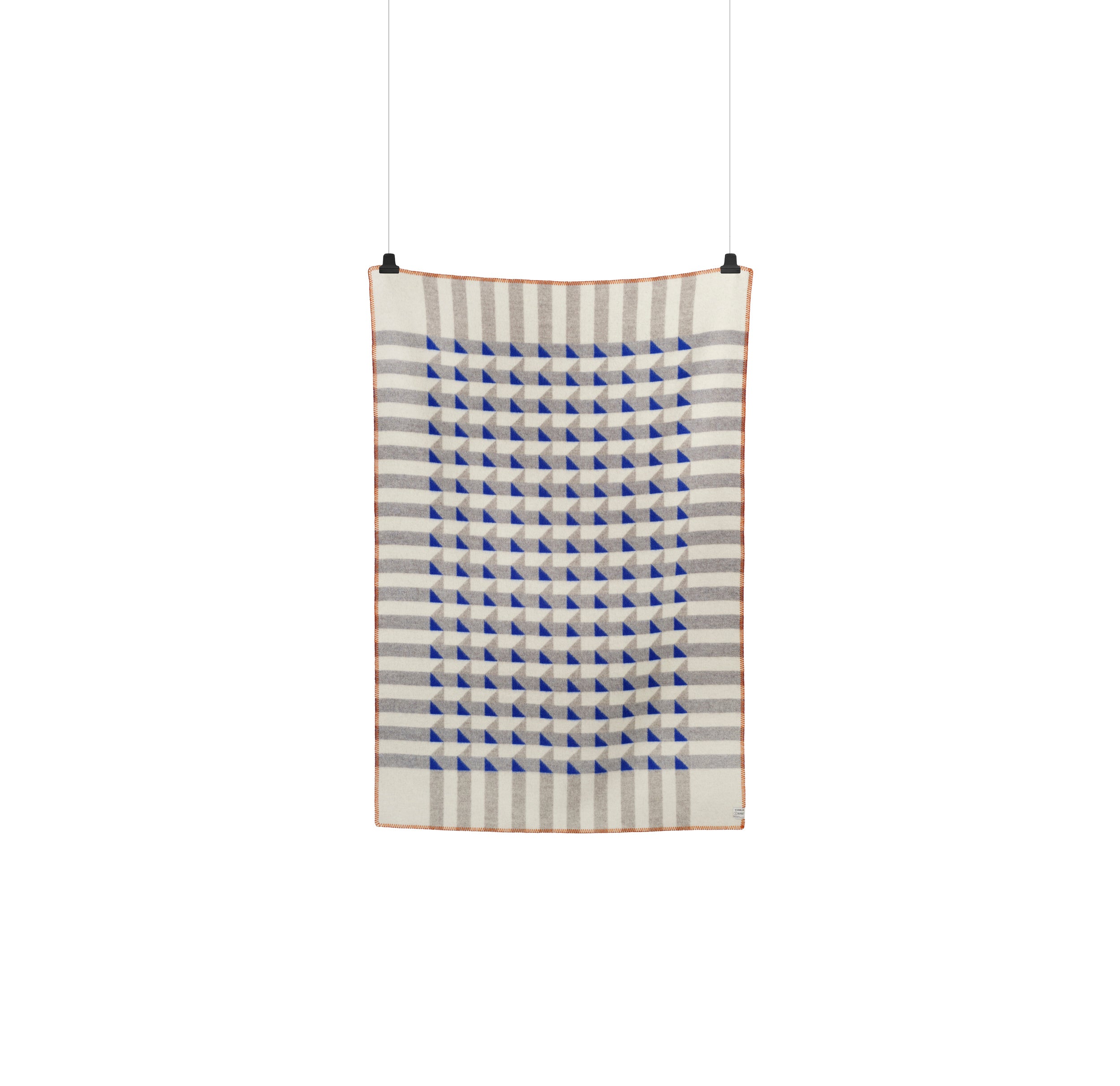 The Roros Kvam Large Throw showcases a jacquard weave with blue and white triangles, encircled by alternating gray and white stripes. It hangs vertically and is bordered by a thin light brown edge.