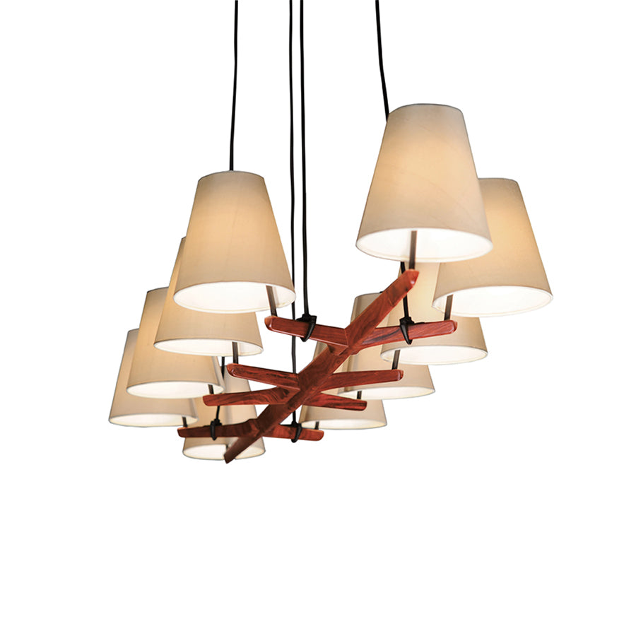 The Kalmar Admont chandelier showcases a modern design with eight natural silk shades in a circular arrangement, suspended by black cords. It includes a red sculptural element featuring branch-like extensions, reflecting the Wiener Werkbund artistic style.
