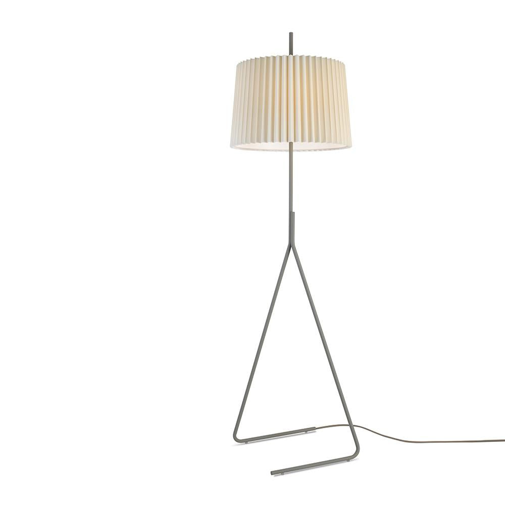 The Fliegenbein BL Floor Lamp by Kalmar features a cream pleated silk shade set on a sleek triangular metal frame, with an elegantly extended visible power cord, embodying modern design.