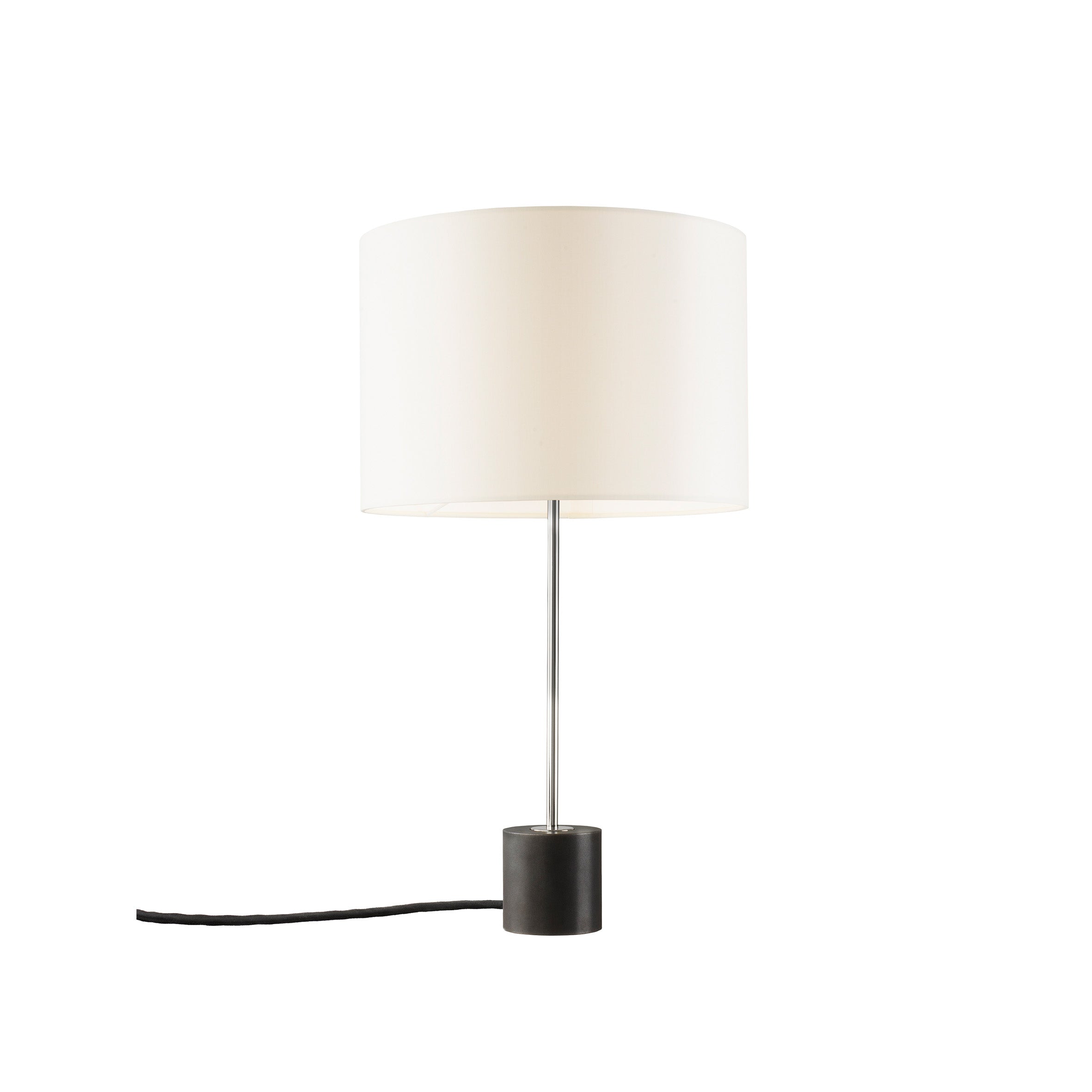 The Kilo Table Lamp by Kalmar offers ambient light with a white cylindrical shade and slim metal stem on a black round base. A black power cord emerges from the base, placed against a plain white background.