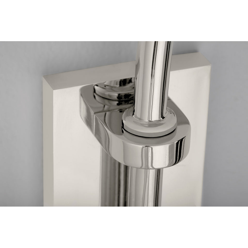 Close-up of a Reibe Wall by Kalmar, featuring a sleek, shiny silver metal pipe mounted on a rectangular bracket against a white wall. The design exudes modern sophistication akin to polished brass finishes.