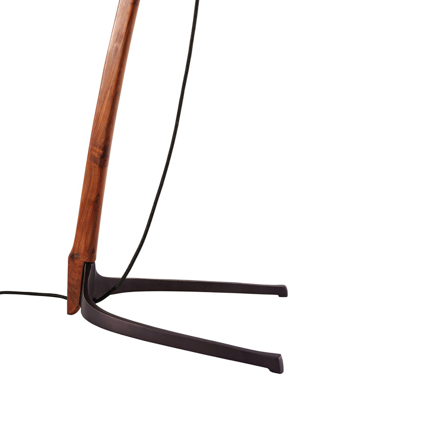 Close-up of the Dornstab Floor from Kalmar, a modern freestanding luminaire with a curved wooden arm leading to a sleek black V-shaped metal stand. This floor lamp draws inspiration from the minimalist elegance of Wiener Werkbund design, with its cord tracing the wooden curve.