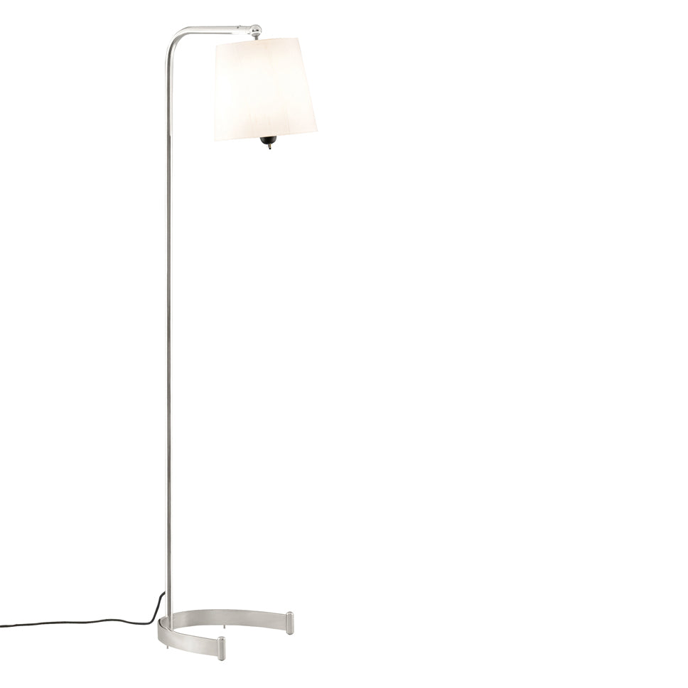 The Egon Floor Lamp by Kalmar features a tall, modern design with a sleek metal pole and pivoting shade. Its minimalist base and black cord complement the white rectangular aesthetic, set against a plain white backdrop for a contemporary feel.