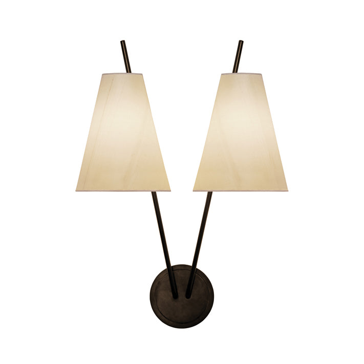 The Kalmar Zweig modern double sconce has two cream conical silk lampshades extending upward from a circular black base. They are angled to create ambient lighting and an elegant inverted V shape.