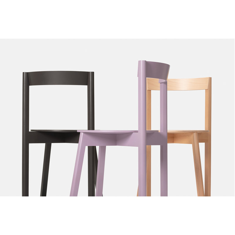 Three minimalist chairs on a white background: black, light wood, and lavender. Their overlapping positions accentuate their modern design and iconic silhouettes. The Loehr L5 JAZZ Side Chair features a striking plywood backrest that stands out among them.
