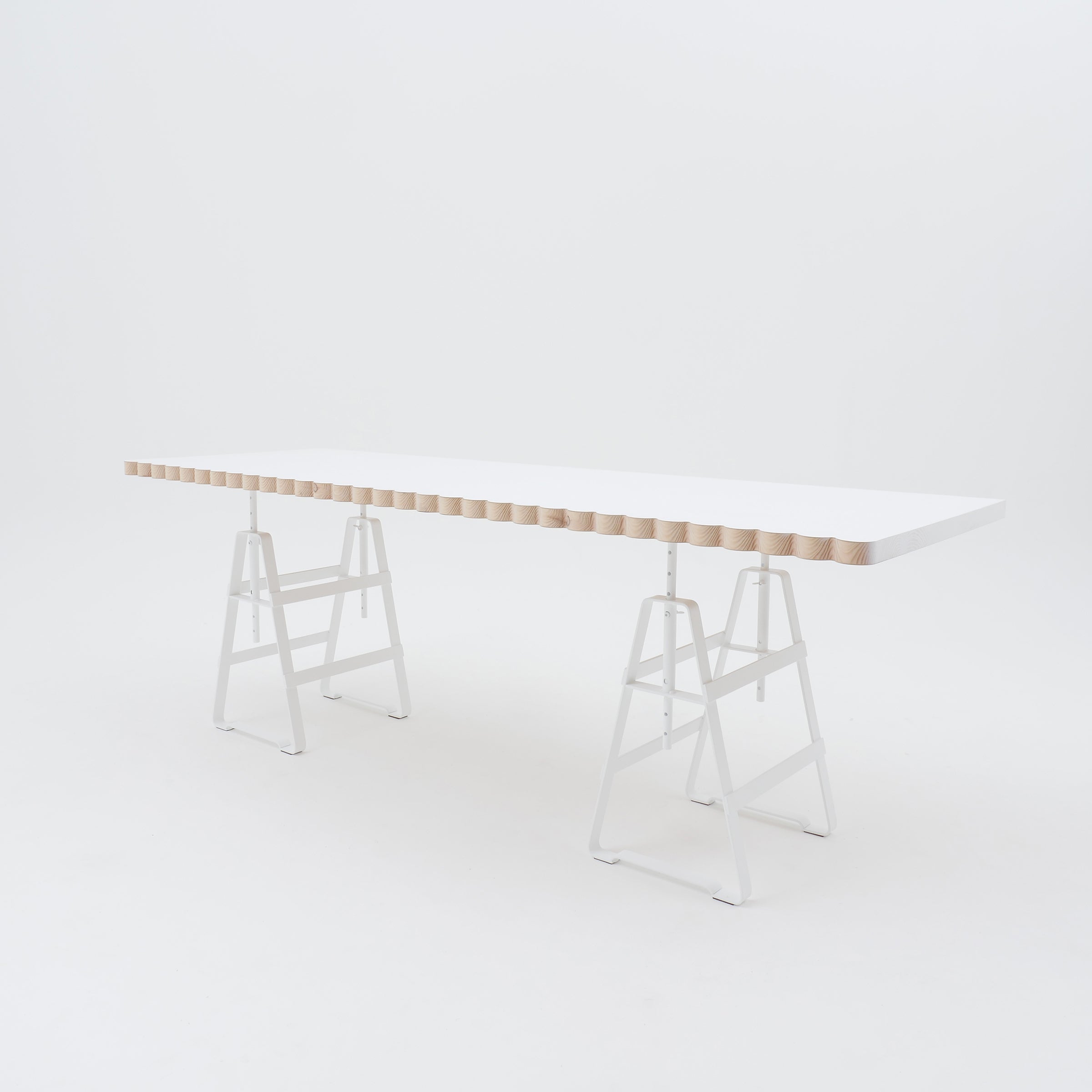 The Lackaffe Trestle by Atelier Haussmann features a minimalist design with a light wood top and powder-coated steel legs. The tabletops undulating edges highlight the elegance typical of Berlin craft producers, set against a white background.
