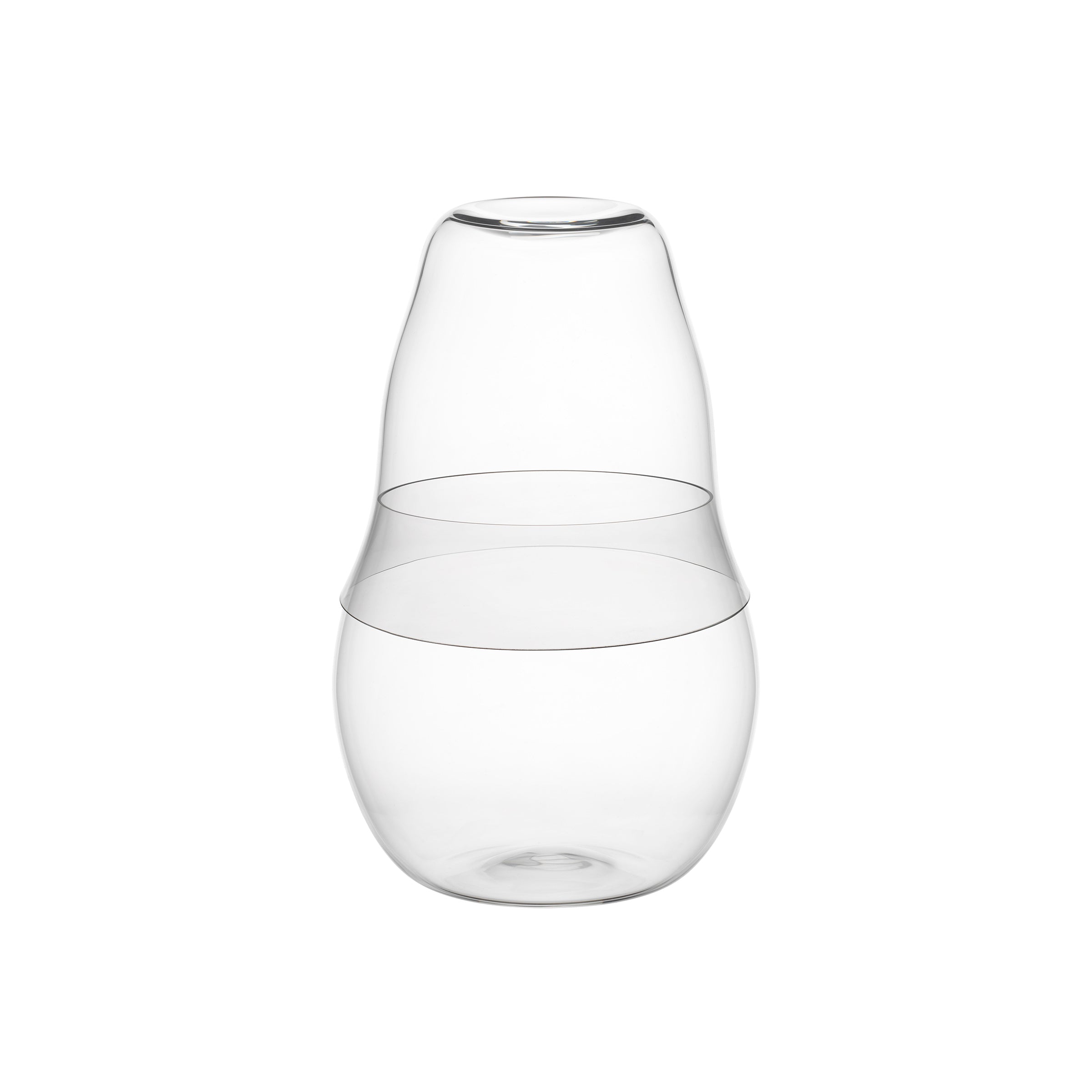 The Reigen Tumbler, a clear glass carafe by Aldo Bakker for Lobmeyr, features an elliptical shape with a wide bottom and narrow neck. Its minimalist top doubles as a detachable cup, inspired by Lobmeyrs elegant tumblers.