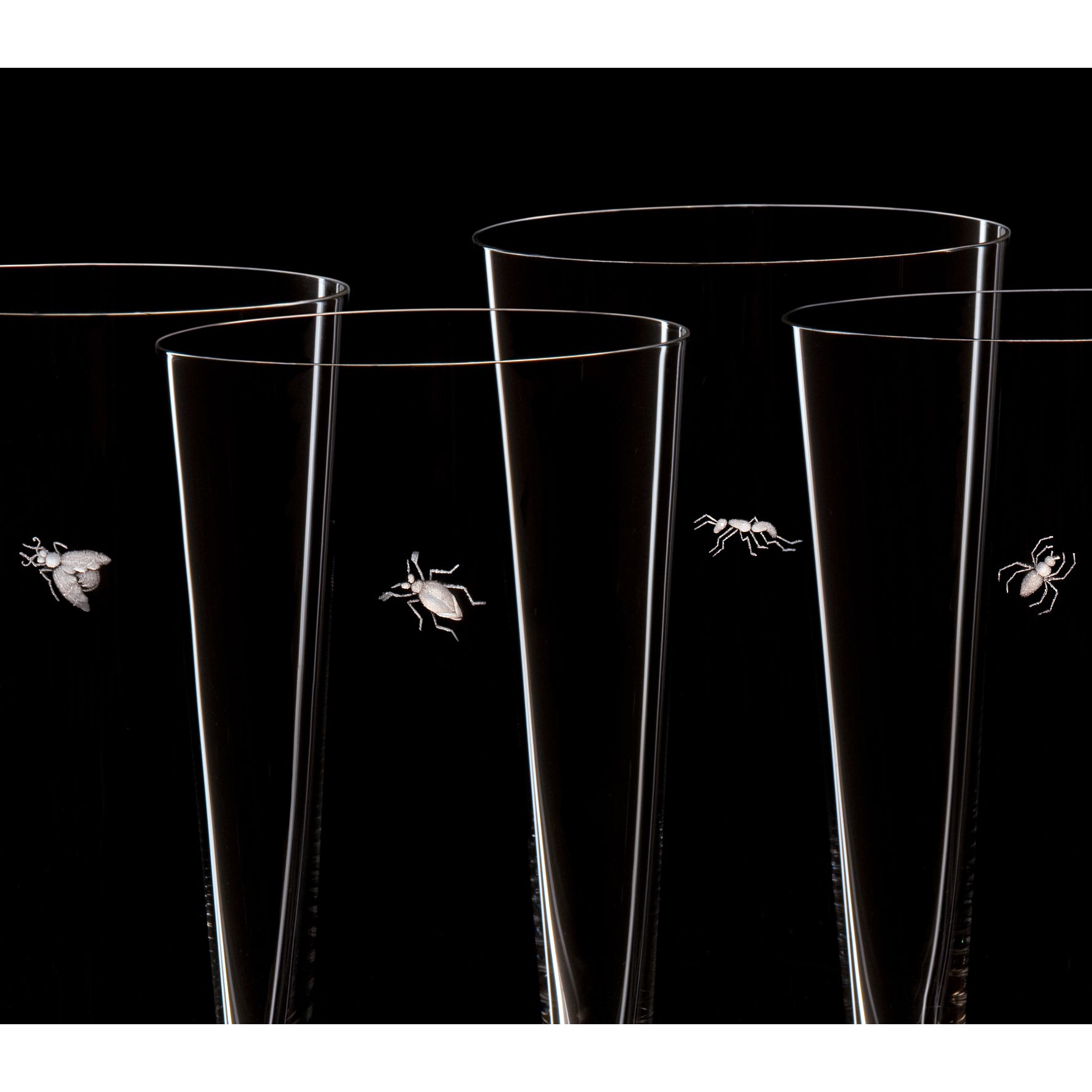 Lobmeyrs Drinking Set No. 257 features four tall, elegant glasses crafted from lead-free crystal with intricate copper wheel engravings of insects like a fly and an ant, set against a black background for a whimsical and artistic touch.