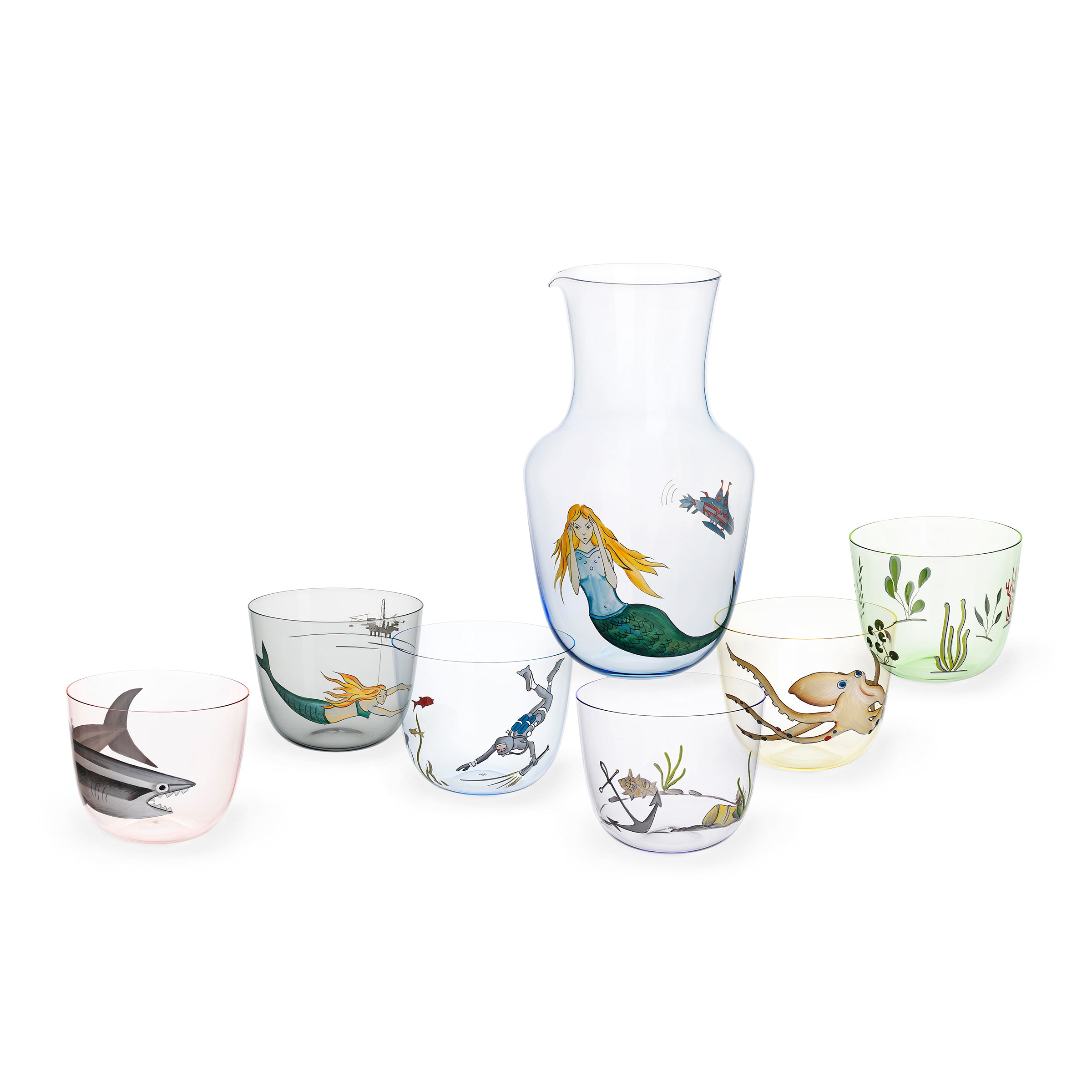The Alpha High Seas collection by Lobmeyr includes a tall mermaid-designed pitcher and six uniquely illustrated ocean-themed tumblers, featuring sharks, fish, and sea plants, all crafted in mouth-blown lead-free crystal and displayed against a white background.