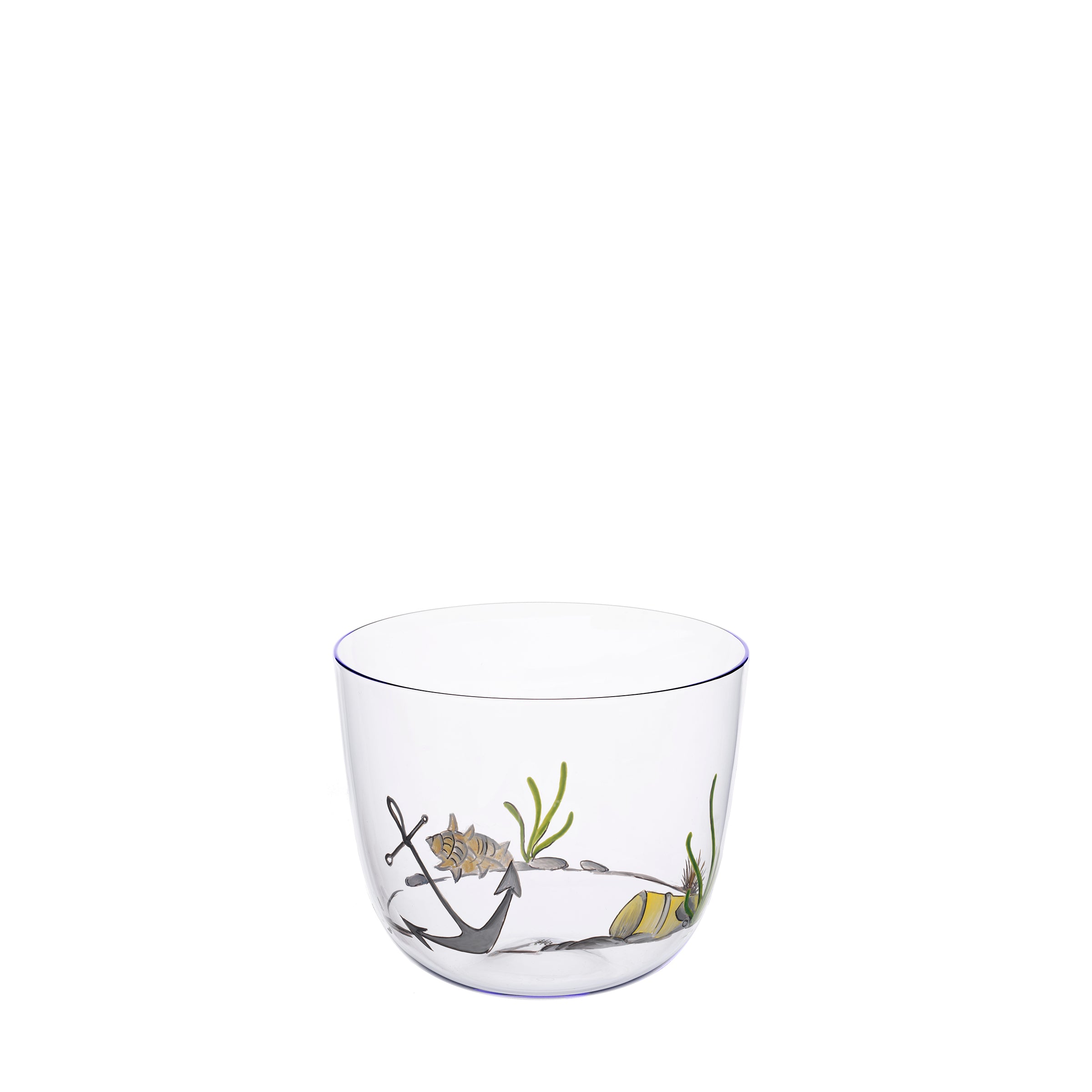 The Alpha High Seas glass by Lobmeyr is crafted from mouth-blown lead-free crystal, featuring nautical designs like anchors, seashells, and seaweed. Its thin blue rim enhances its elegance against a plain white background.