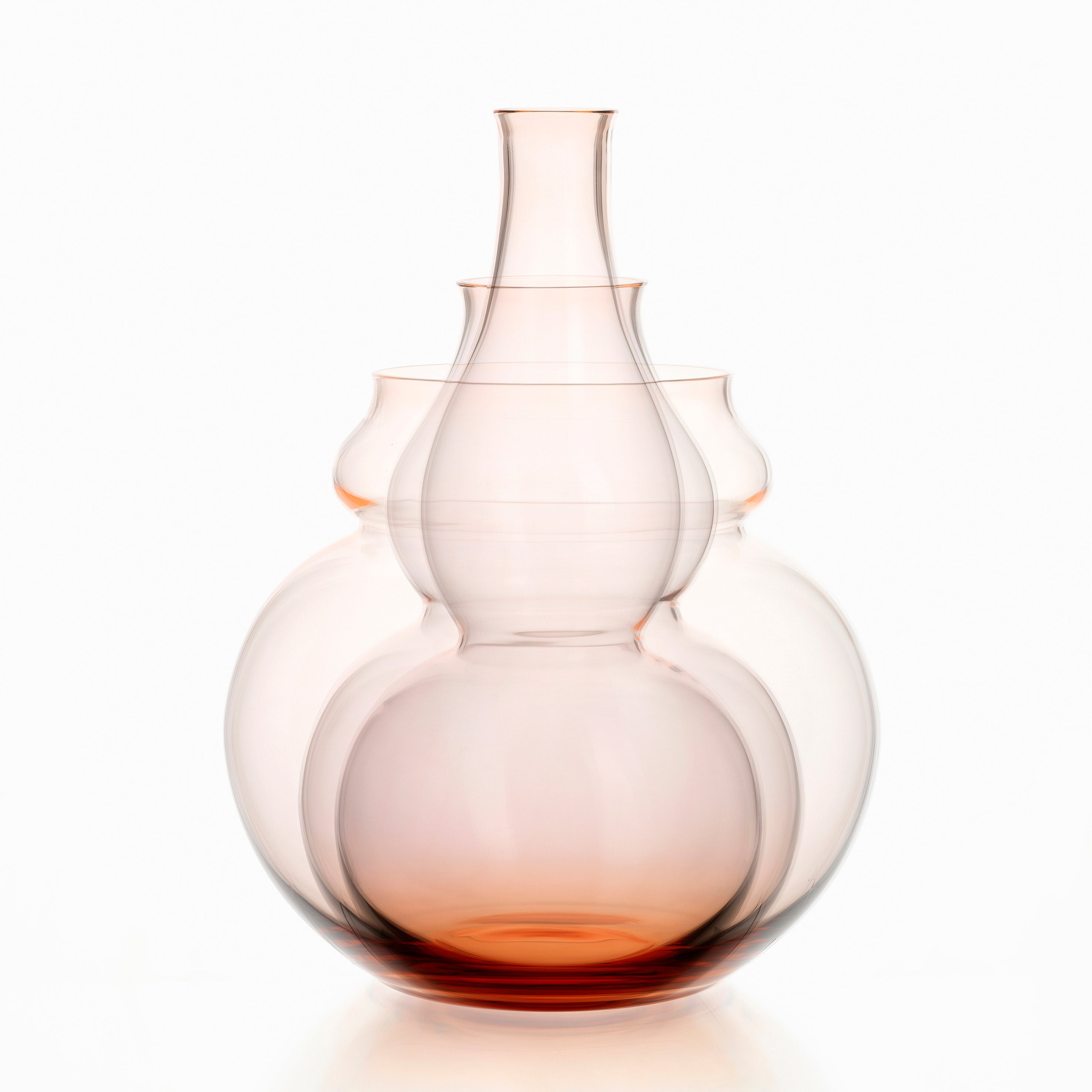 The BV71 Calabash Flower Vase set by Lobmeyr features three nested glass vases with bulbous shapes and narrow necks. They artistically transition from clear to warm amber, resembling a calabash gourd, and create a layered effect against a white background.