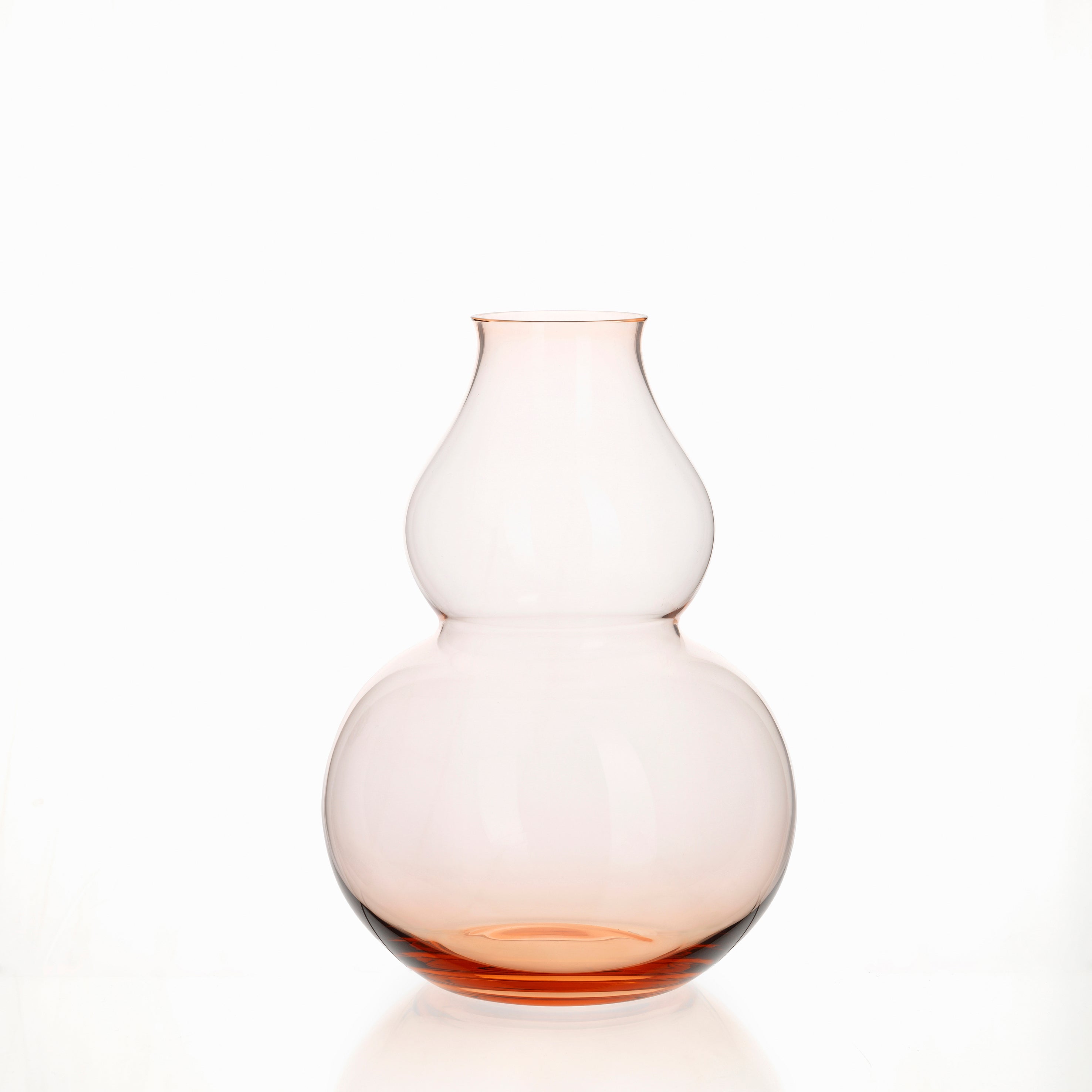 The BV71 Calabash Flower Vase by Lobmeyr is a mouth-blown, lead-free crystal vase with a translucent double-gourd shape and subtle pink tint, echoing the elegance of porcelain against its plain white backdrop.