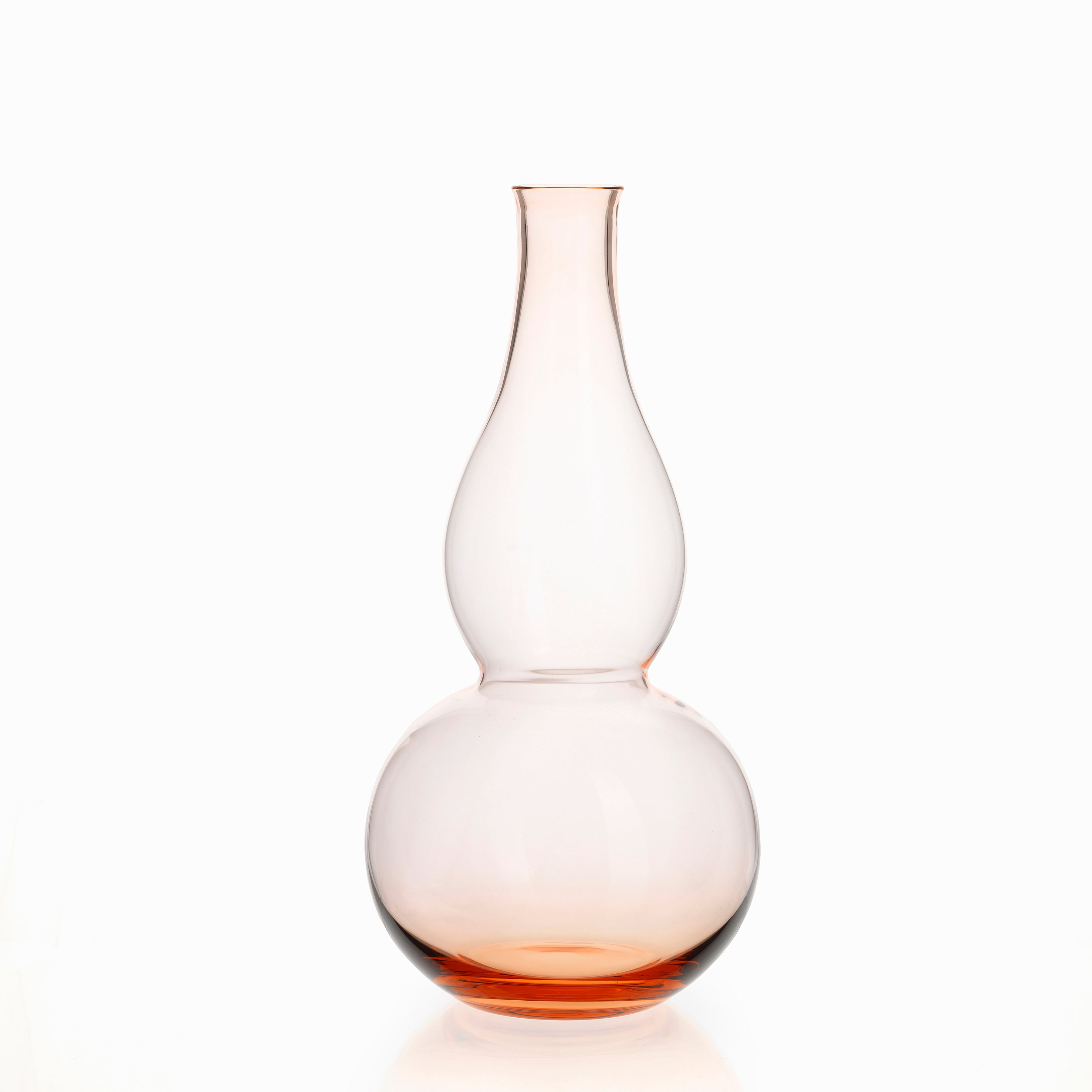 The BV71 Calabash Flower Vase by Lobmeyr features an elongated shape and a wide, round base tapering into a narrow neck. Made from mouth-blown, lead-free crystal, it transitions subtly from clear to pale orange, offering sophistication against any white background.