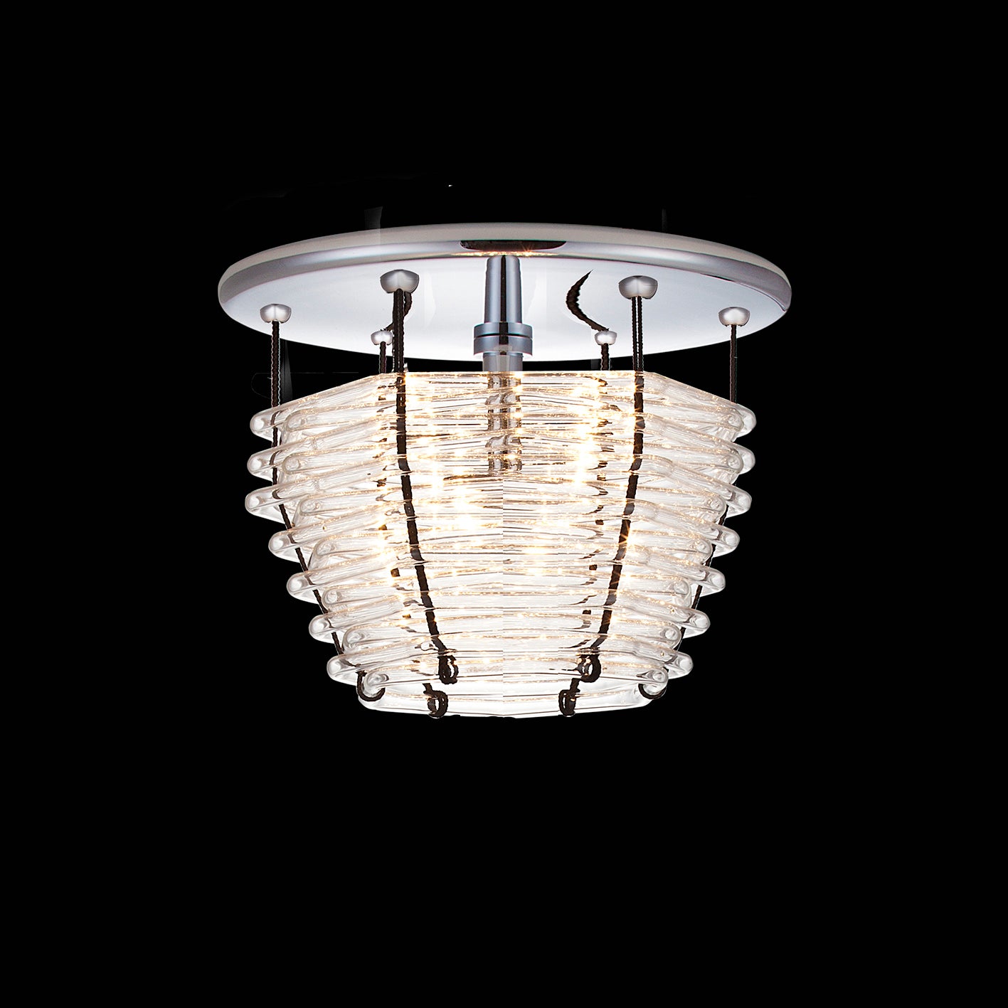 The Basket Ceiling by Lobmeyr is a modern ceiling light with a circular white base and elegantly tapered hexagonally bent glass tubes, set against a black background.