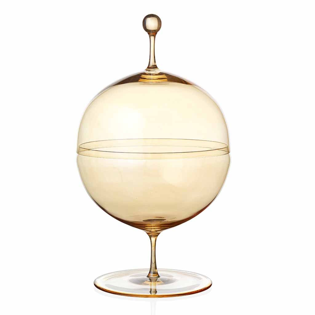 The Candy Dish Gold Lustre by Lobmeyr is inspired by Oswald Haerdtl and features a transparent, spherical design with a decorative knob on the lid. Elevated on an elegant stem with a round base, its crafted from mouth-blown lead-free crystal in pale amber, adding warmth and sophistication to any setting.