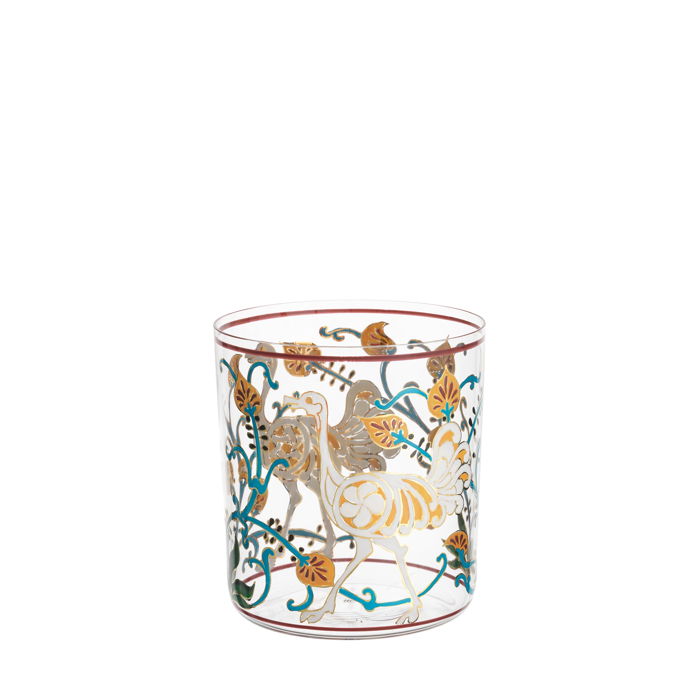 The Alhambra DOF Tumbler by Lobmeyr is a clear glass adorned with gold and turquoise floral and bird patterns, detailed leaves, and griffin-like creatures, reminiscent of the Alhambra palace for an ornate and elegant look.