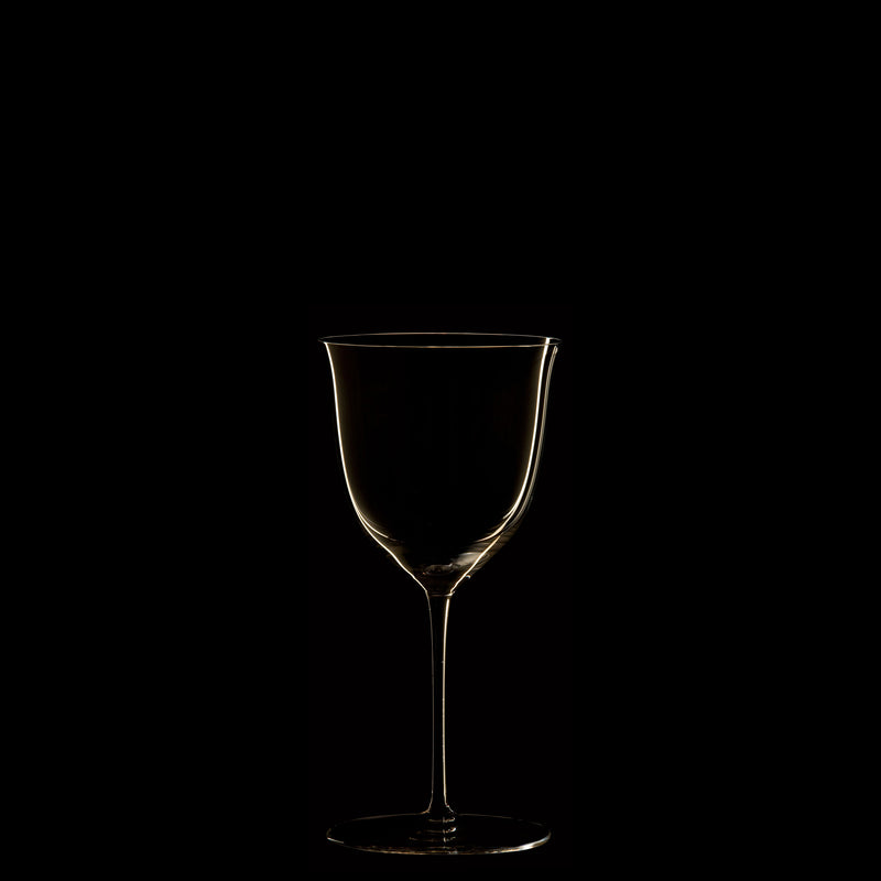 The silhouette of an empty wine glass from the Lobmeyr Drinking Set No. 238 - Patrician against a black background evokes the minimalist elegance of Wiener Werkstätte, highlighted to create a sophisticated appearance.