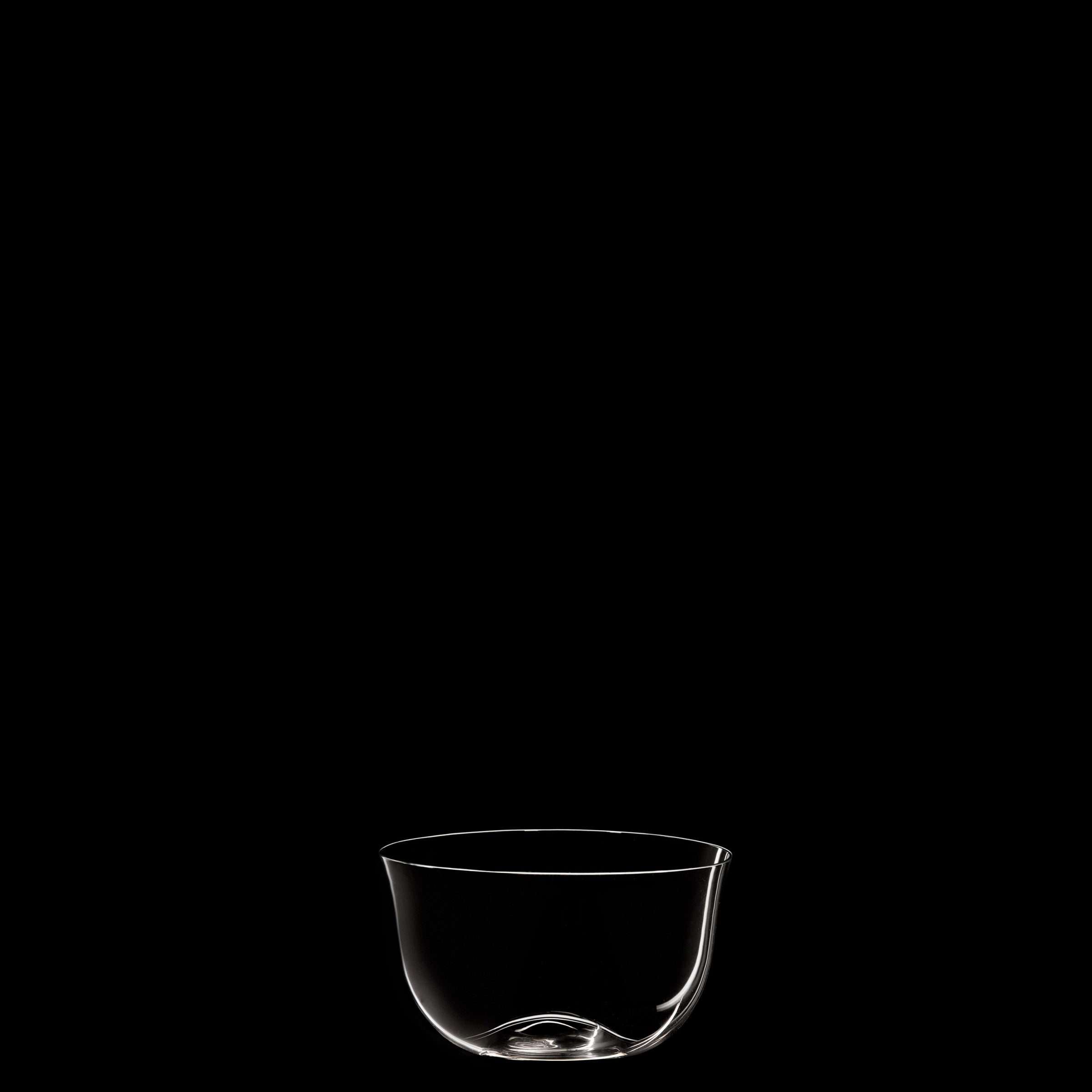 A piece from Lobmeyrs Drinking Set No. 238 - Patrician, made of mouth-blown crystal with a rounded base, is set against a plain black background for a minimalist and elegant look.