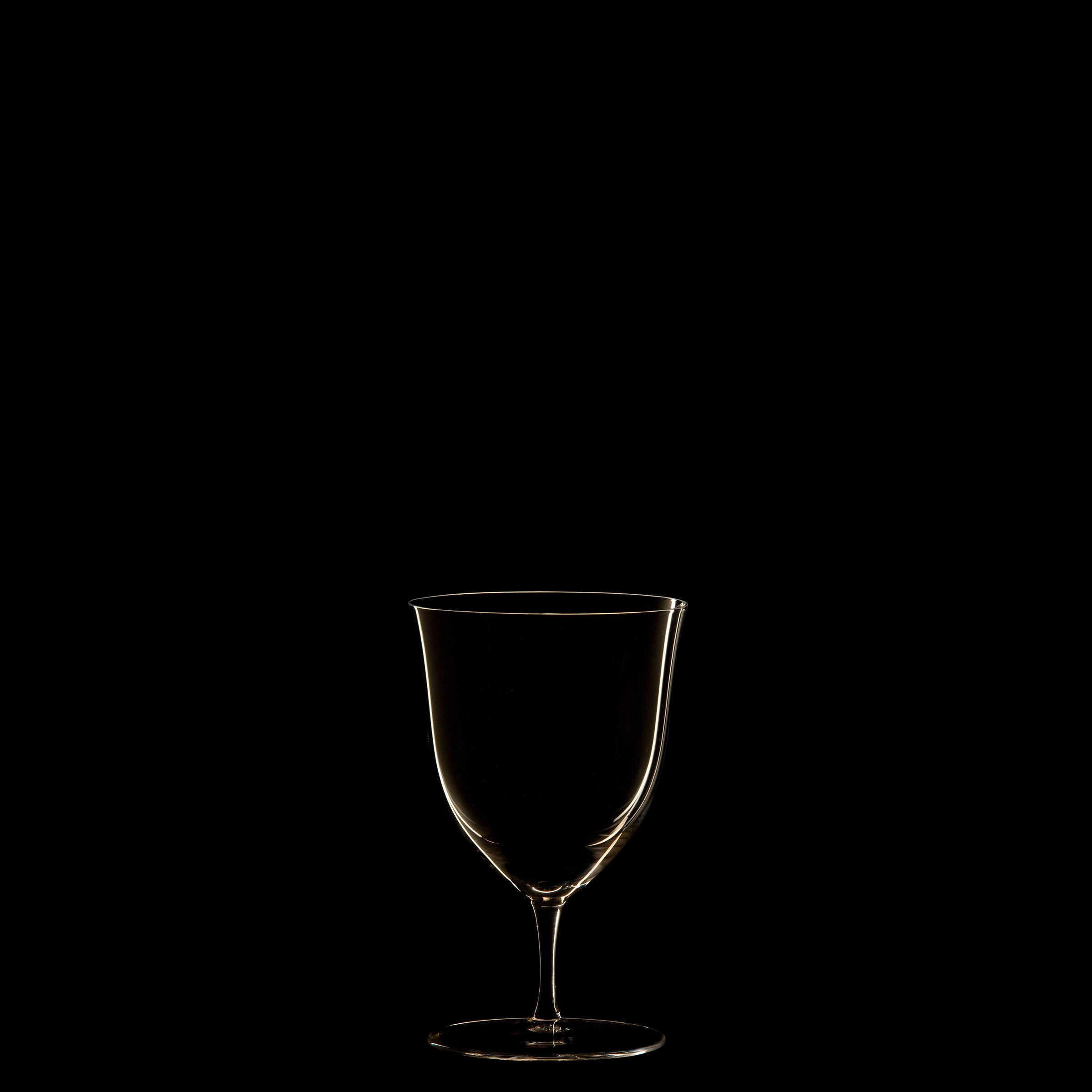 Lobmeyrs Drinking Set No. 238 - Patrician features a transparent wine glass, echoing Josef Hoffmanns Wiener Werkstätte style, outlined subtly against a black background to highlight its delicate contours and smooth curves in exquisite mouth-blown crystal.