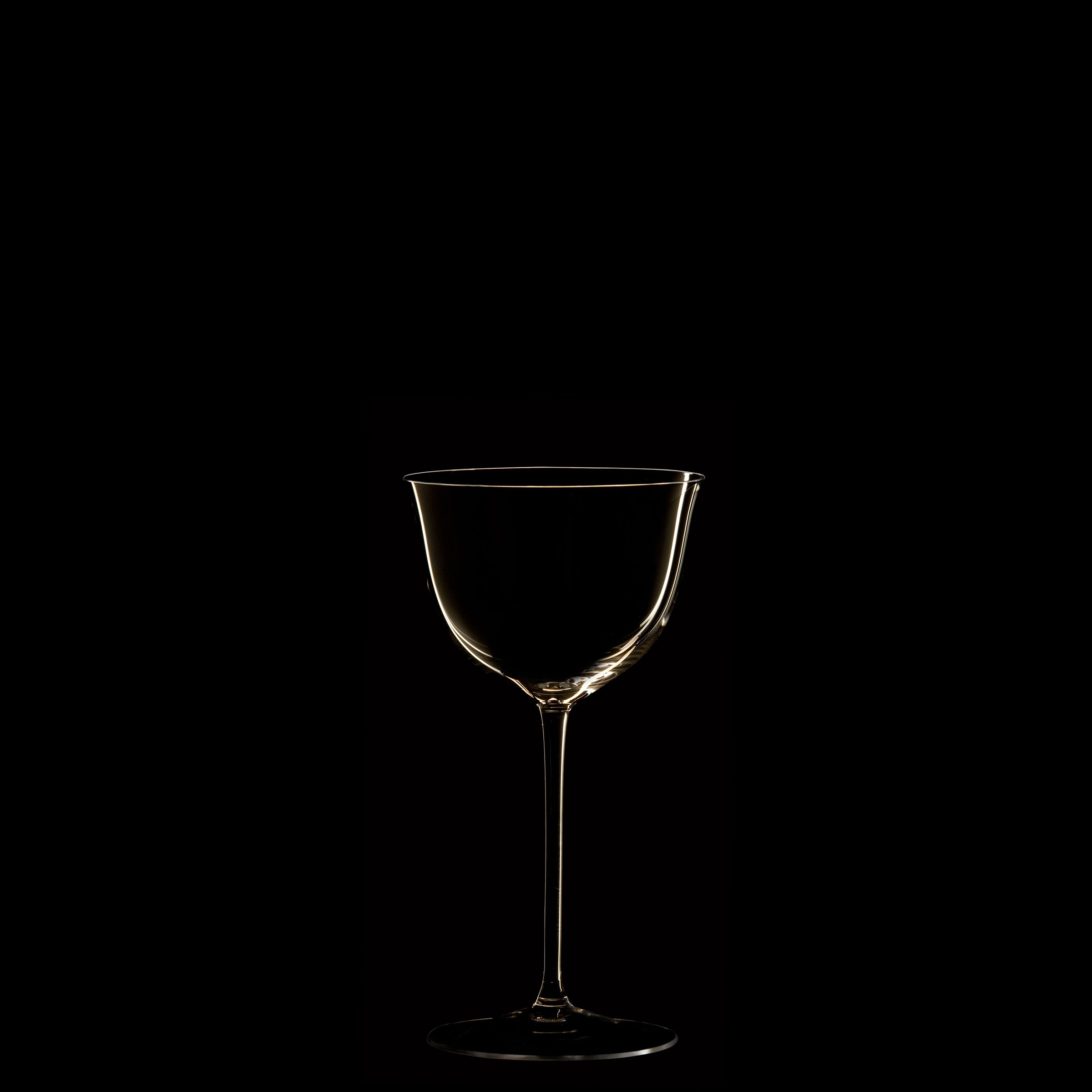 The Drinking Set No. 238 - Patrician by Lobmeyr features a single mouth-blown crystal wine glass, elegantly silhouetted against a black background with light reflecting delicately on its rim and stem.