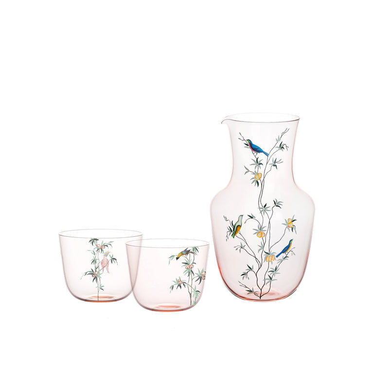 Experience the Garden of Paradise with Lobmeyrs Alpha Pitcher and coordinating hand-painted tumblers, featuring delicate bird and tree branch designs in a soft pink rosalin hue.