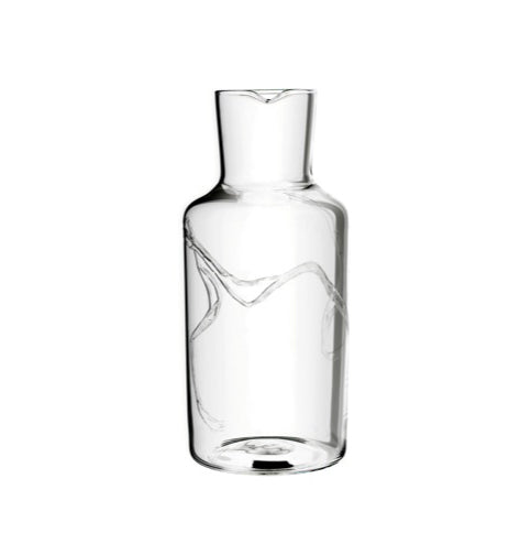 The Fortune Series by Lobmeyr is a clear glass water carafe with a sleek cylindrical design and small top spout. Its mouth-blown crystal surface has subtle wavy patterns for a modern, elegant look.