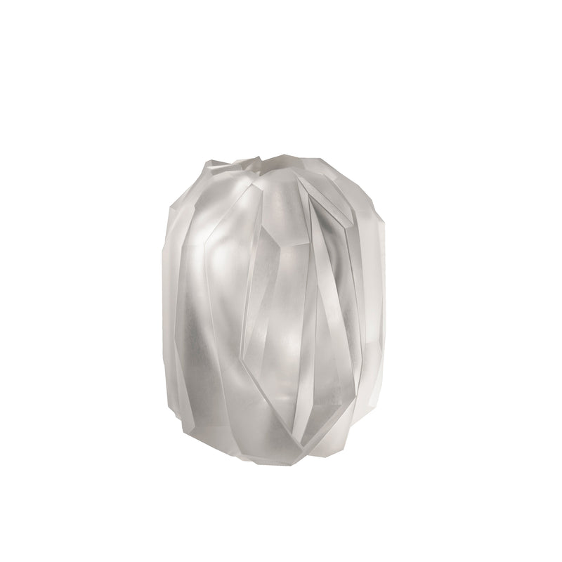 The Gletscher Vase by Lobmeyr features a translucent, multi-faceted design with an abstract geometric pattern. Its pale, milky appearance and smooth texture resemble a roughly cut gemstone, boasting angular edges and the elegance of hand-cut crystal.