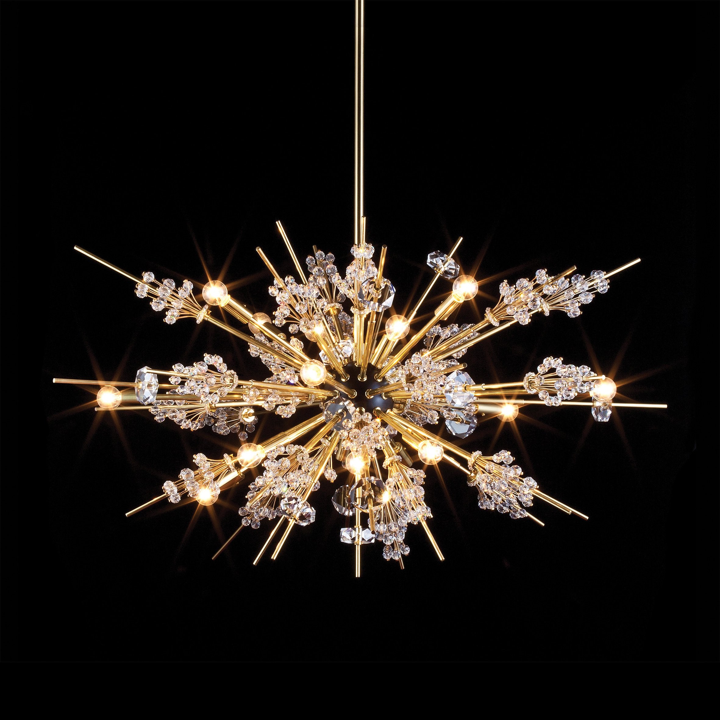 The Auditorium chandelier from Lobmeyrs The Met Series features a starburst design with a gold finish, boasting Swarovski crystal-embellished rods radiating from a central sphere. It is displayed on a black background and illuminated for a dazzling effect.