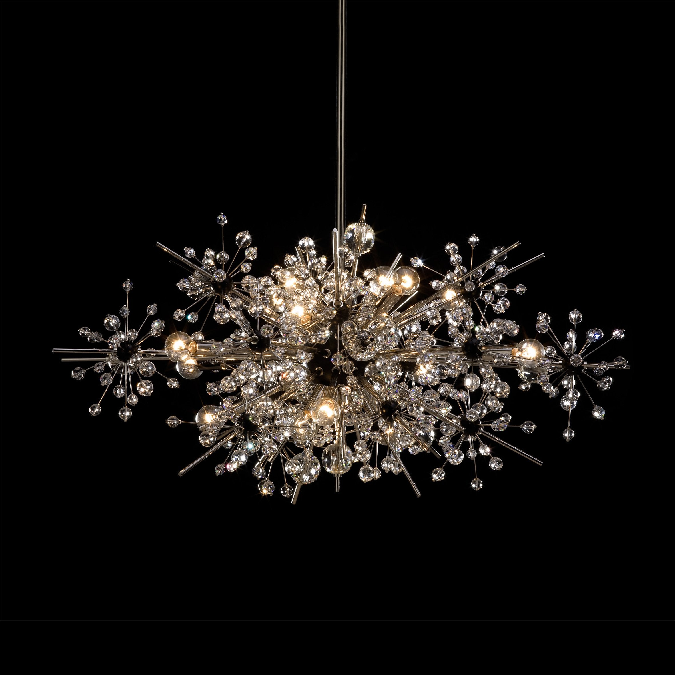 The Foyer - The Met Series by Lobmeyr is a modern chandelier with an intricate starburst design. It features numerous metallic rods and Swarovski crystal-like spheres, illuminated by several light bulbs against a black background.