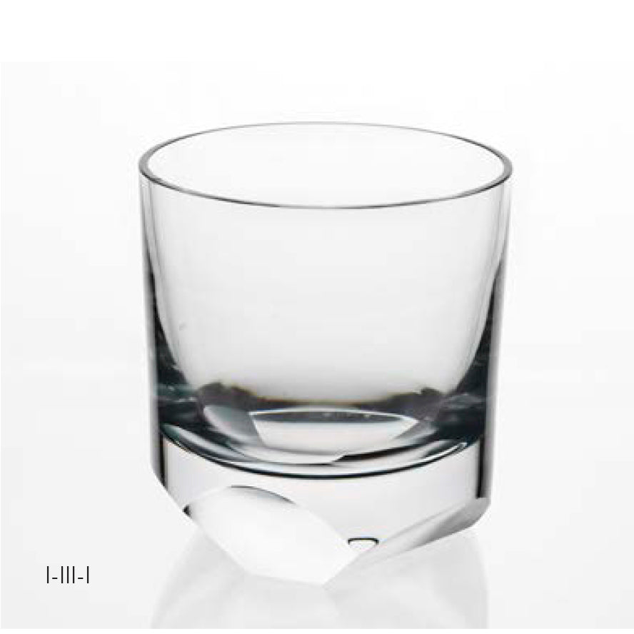The Lobmeyr Neo Cut I Collection whiskey tumbler, admired at Vienna Design Week, rests empty on a white surface. Its clear glass and thick base create a contemporary ornament with a simple cylindrical shape and smooth appearance.