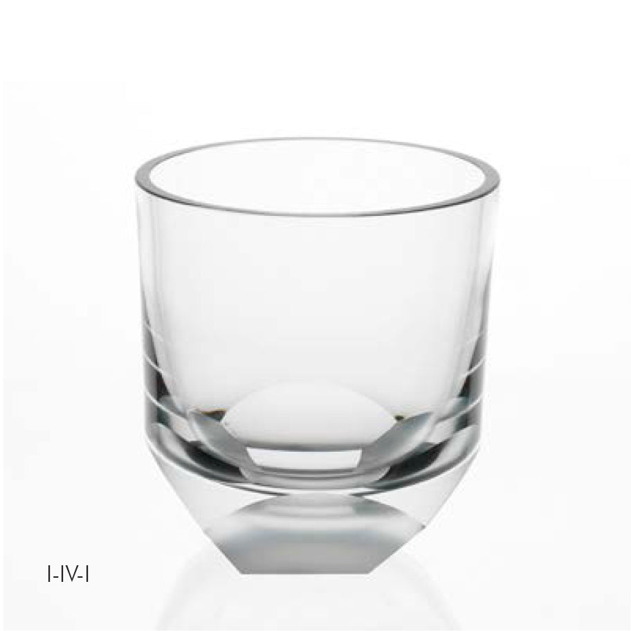 The Lobmeyr Neo Cut I whiskey tumbler features clear glass with a thick, tapered base and straight sides on a reflective surface, embodying minimalist, elegant design lines that capture the innovative spirit celebrated at Vienna Design Week.