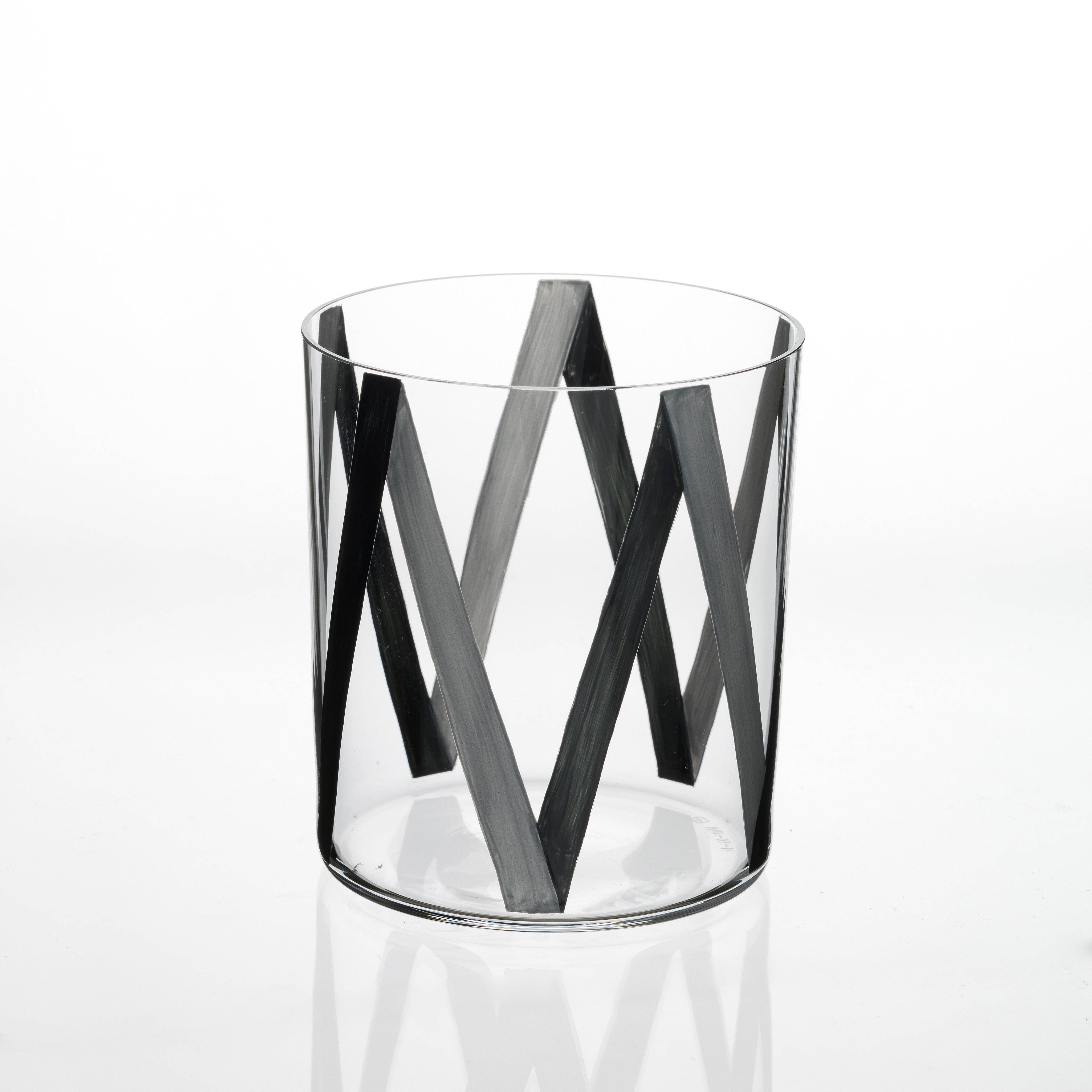 The Neo Light VIII Enamel Collection by Lobmeyr, designed by Martino Gamper, showcases a contemporary ornament charm with its clear glass adorned with a black zigzag geometric pattern on a pristine white backdrop, artfully blending aesthetics and functionality.