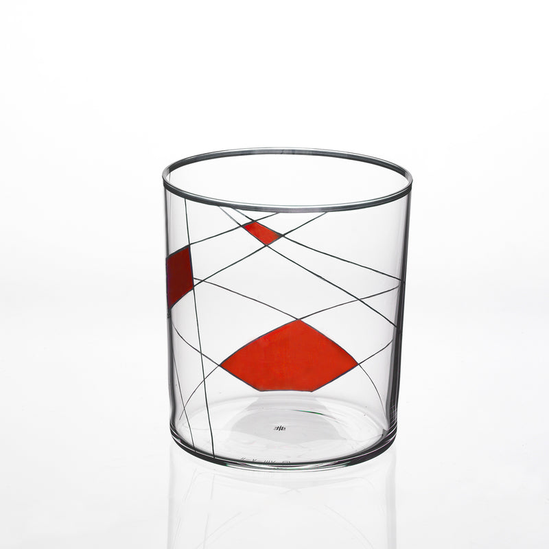 The Neo Light X by Lobmeyr is a clear glass tumbler, adorned with intersecting black lines and bold red diamond shapes, exuding contemporary elegance reminiscent of Martino Gamper’s design.