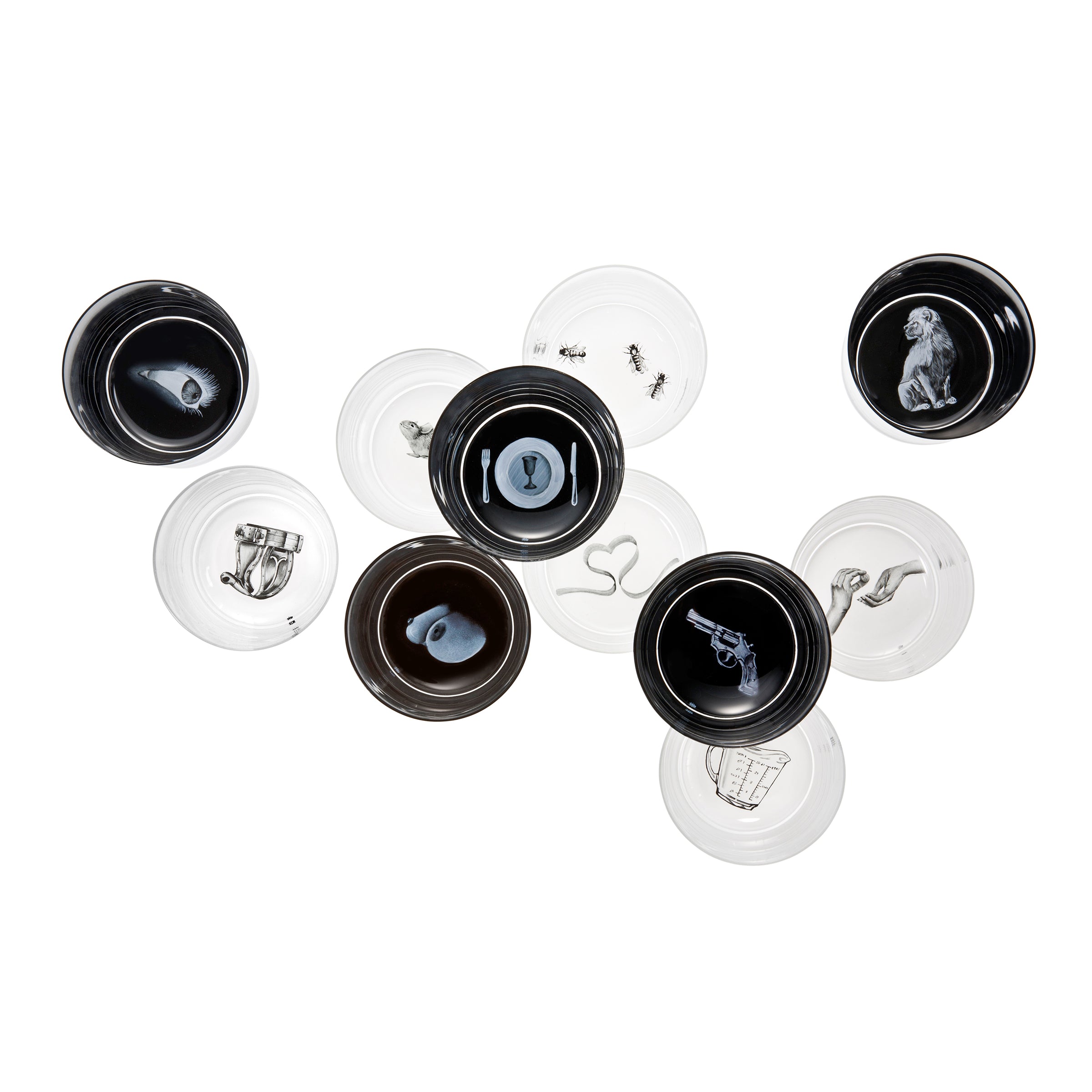 The Drinking Set No. 248 - Sagmeister on Loos, by Lobmeyr, offers a striking display of black and white ceramic plates with hand-painted crystal designs, including distinctive illustrations like a dog, gun, ants, and boot on a pristine white background.