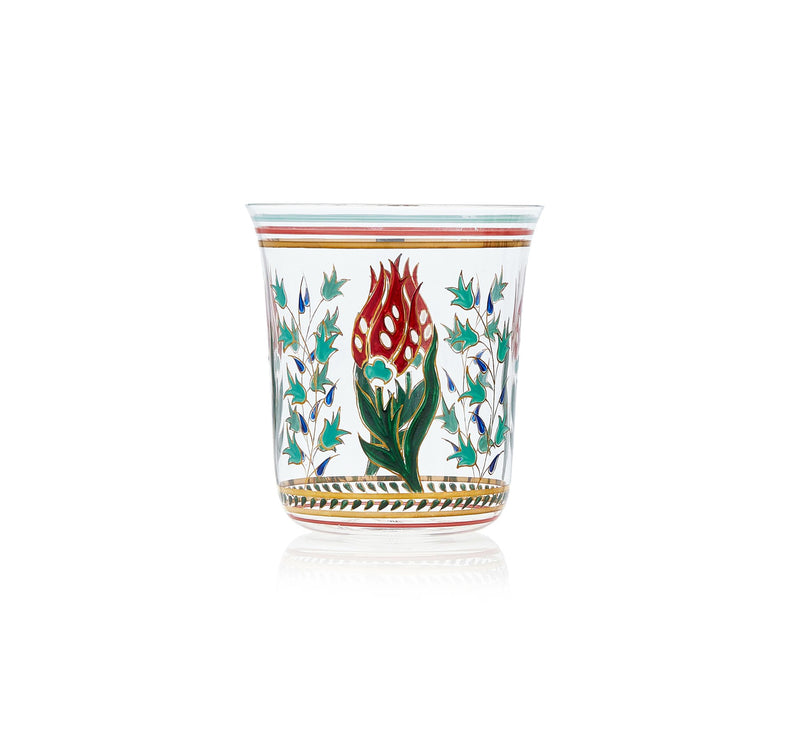 The Oriental Flower Tumbler by Lobmeyr is a clear glass, hand-painted crystal with intricate oriental floral designs. It features a large red flower with green leaves, surrounded by smaller blue flowers and foliage, and has gold rim accents for added elegance.