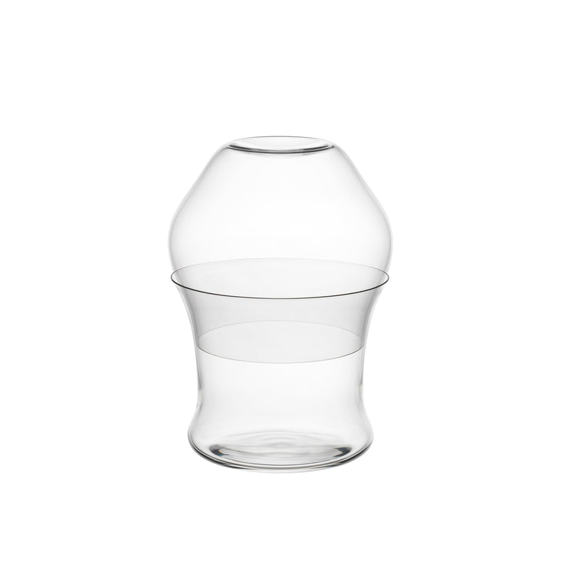 A clear, uniquely shaped glass vase with a modern, curved design reminiscent of Aldo Bakker features a wider bulbous top that narrows in the middle before widening at the base, beautifully complementing your collection of Lobmeyr Reigen tumblers.