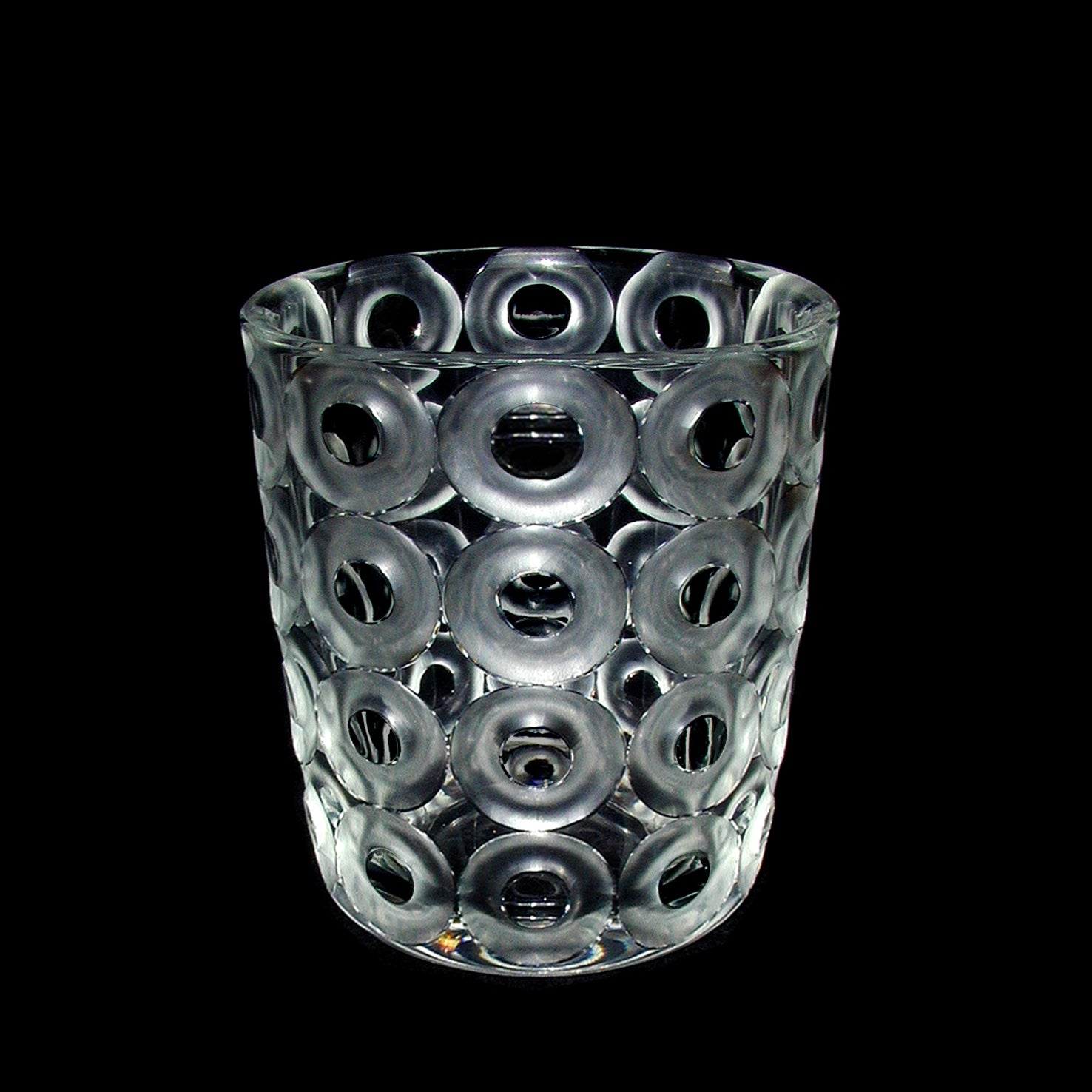The Hoffmann Ring Vase by Lobmeyr is a limited edition clear glass tumbler featuring a textured design with hand-cut and polished raised circular patterns on a black background.