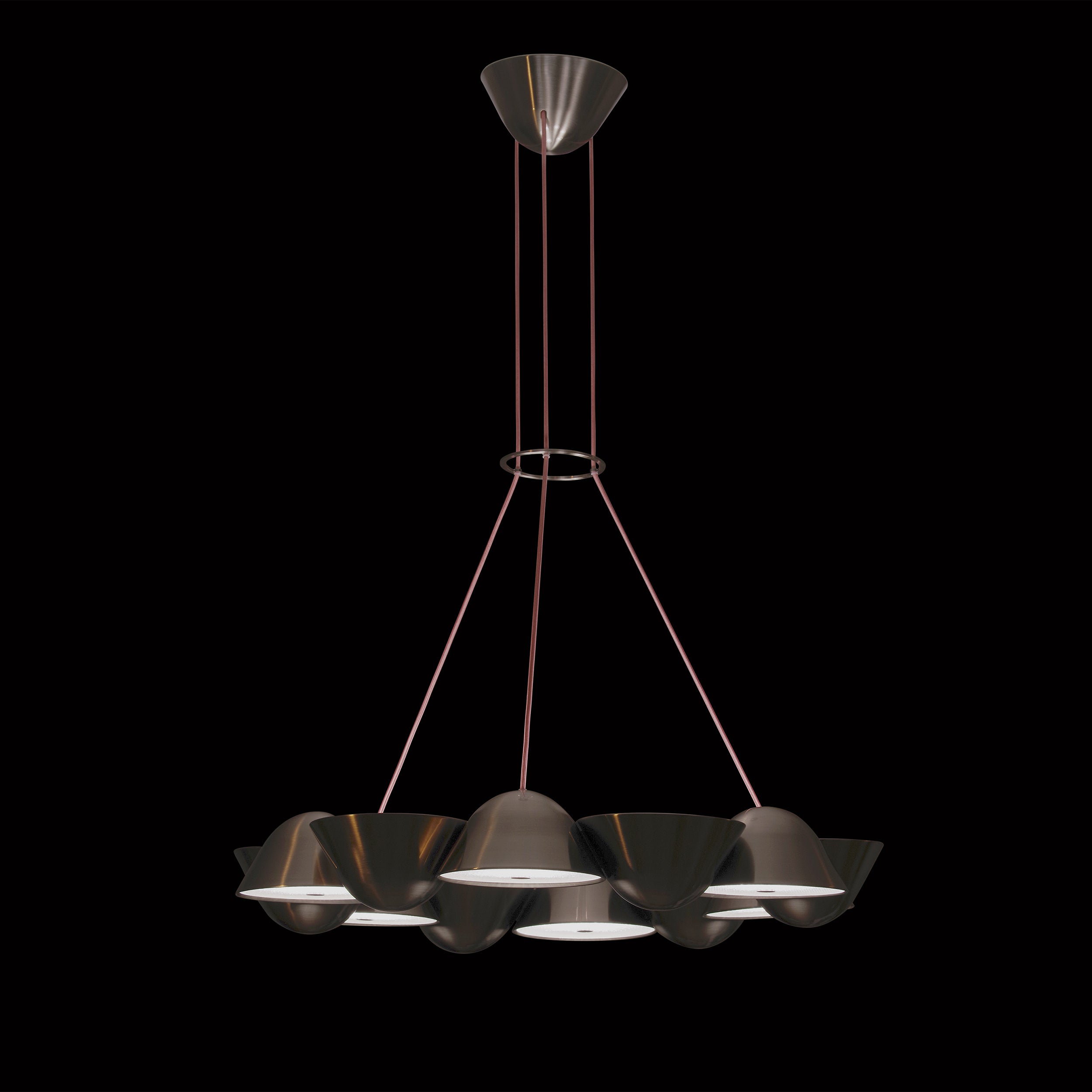 Lobmeyrs The Knight 12 is a smart chandelier with a sleek black metallic finish, featuring modular LED lighting. Six shades are arranged in a circular pattern, suspended by thin rods against the black backdrop.