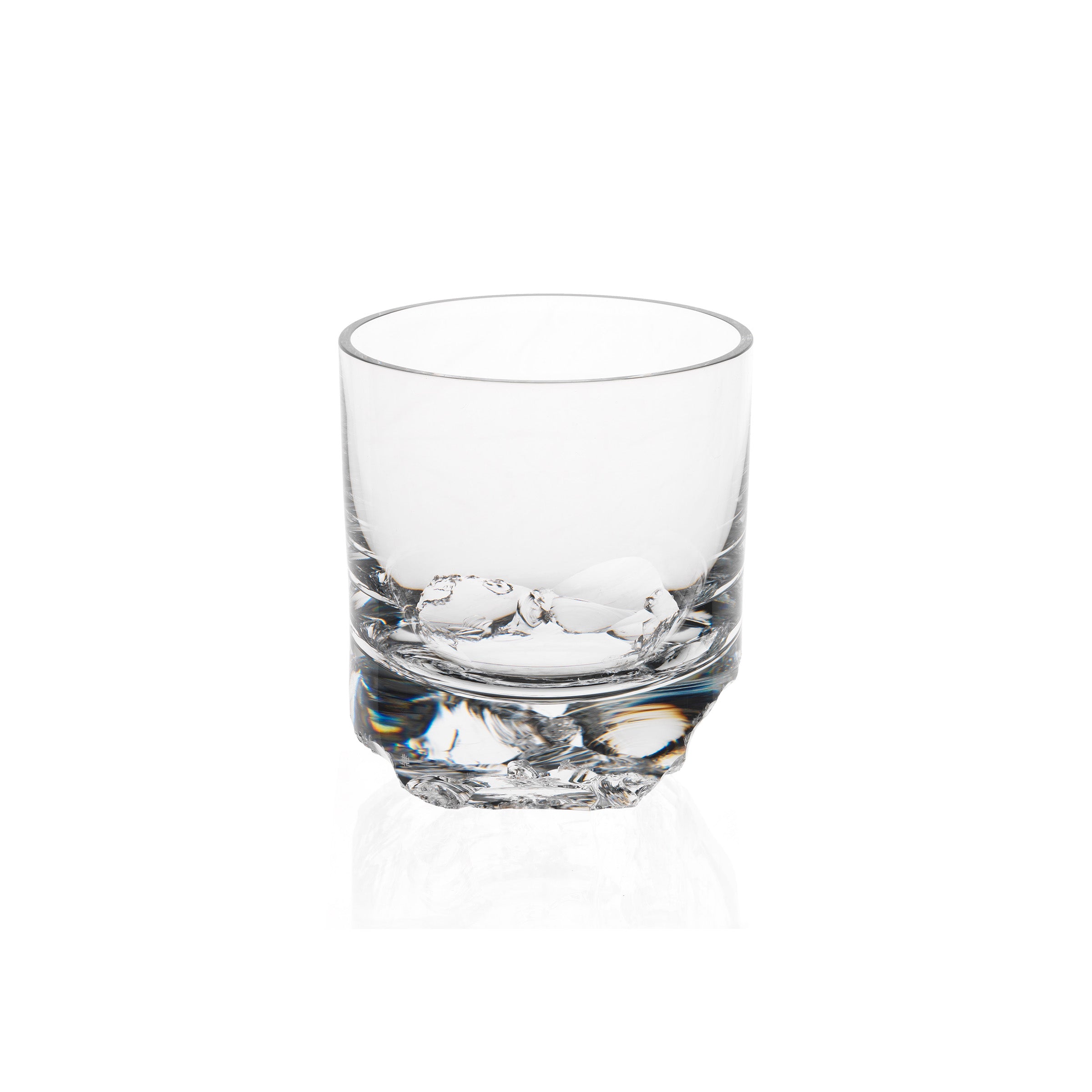 A Lobmeyr Bar Series - Flint tumbler, designed by Michael Anastassiades, stands empty against a plain white background. Its simple cylindrical shape is elegantly highlighted by light reflections on the clear glass and thick base.