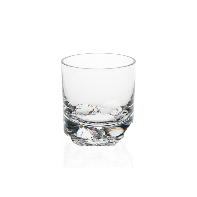 A Lobmeyr Bar Series - Flint tumbler, designed by Michael Anastassiades, stands empty against a plain white background. Its simple cylindrical shape is elegantly highlighted by light reflections on the clear glass and thick base.