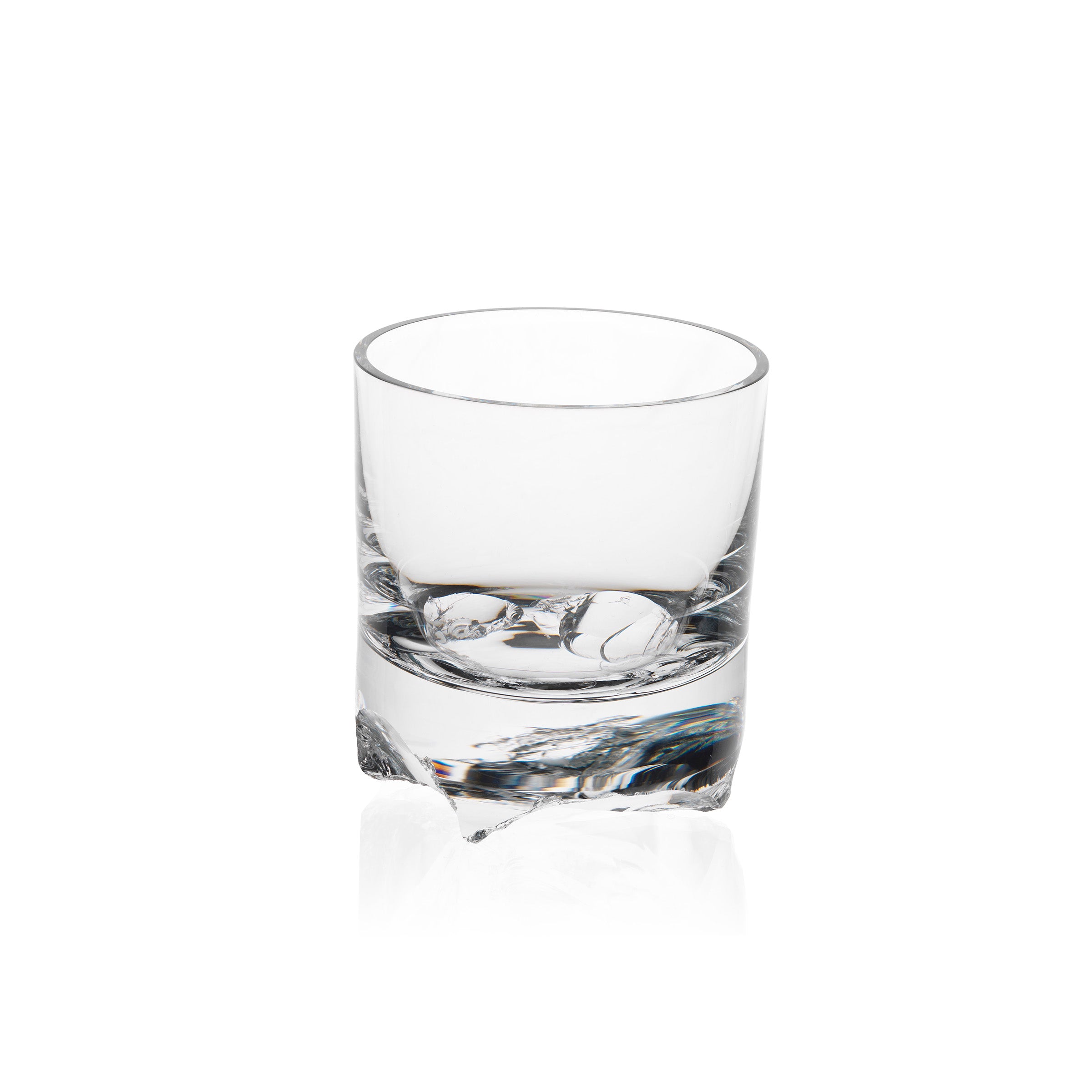 A clear Flint tumbler from the Bar Series by Lobmeyr is seen on a white background, slightly elevated. Designed by Michael Anastassiades, it has a thick base and smooth, cylindrical sides casting faint shadows below.