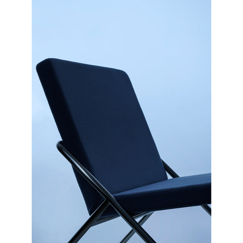 Close-up of the DL2 Euclides Two-Seater by Loehr, featuring a sleek, minimalist design. The upholstered dark blue seating is supported by a crisscross metal frame, with a light blue gradient background enhancing the calm atmosphere.