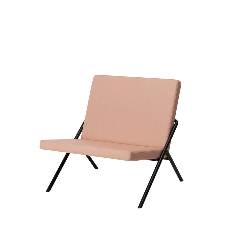 The DL2 Euclides Lounge Chair by Loehr features an elegant minimalist design with a light pink cushioned seat and backrest. It has a sleek black metal frame with angled legs, perfectly showcased against a plain white background.