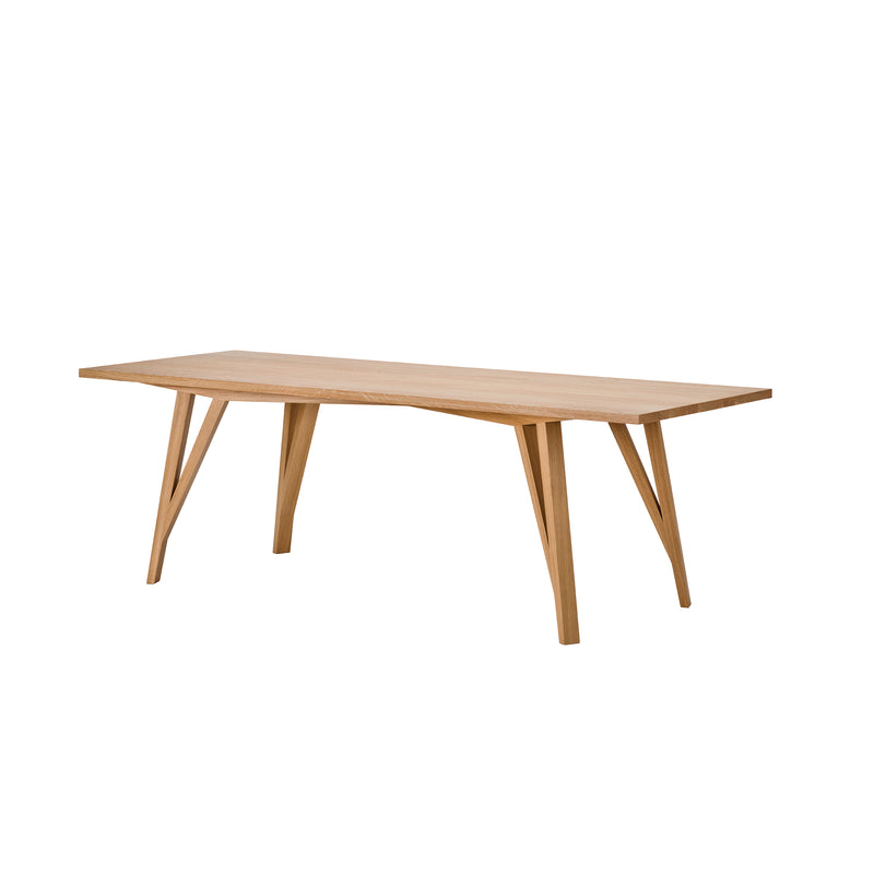 The JL5 Sabeth Table by Loehr is a modern dining table made of solid oak, featuring a smooth rectangular top and slim, angled legs, set against a plain white background.