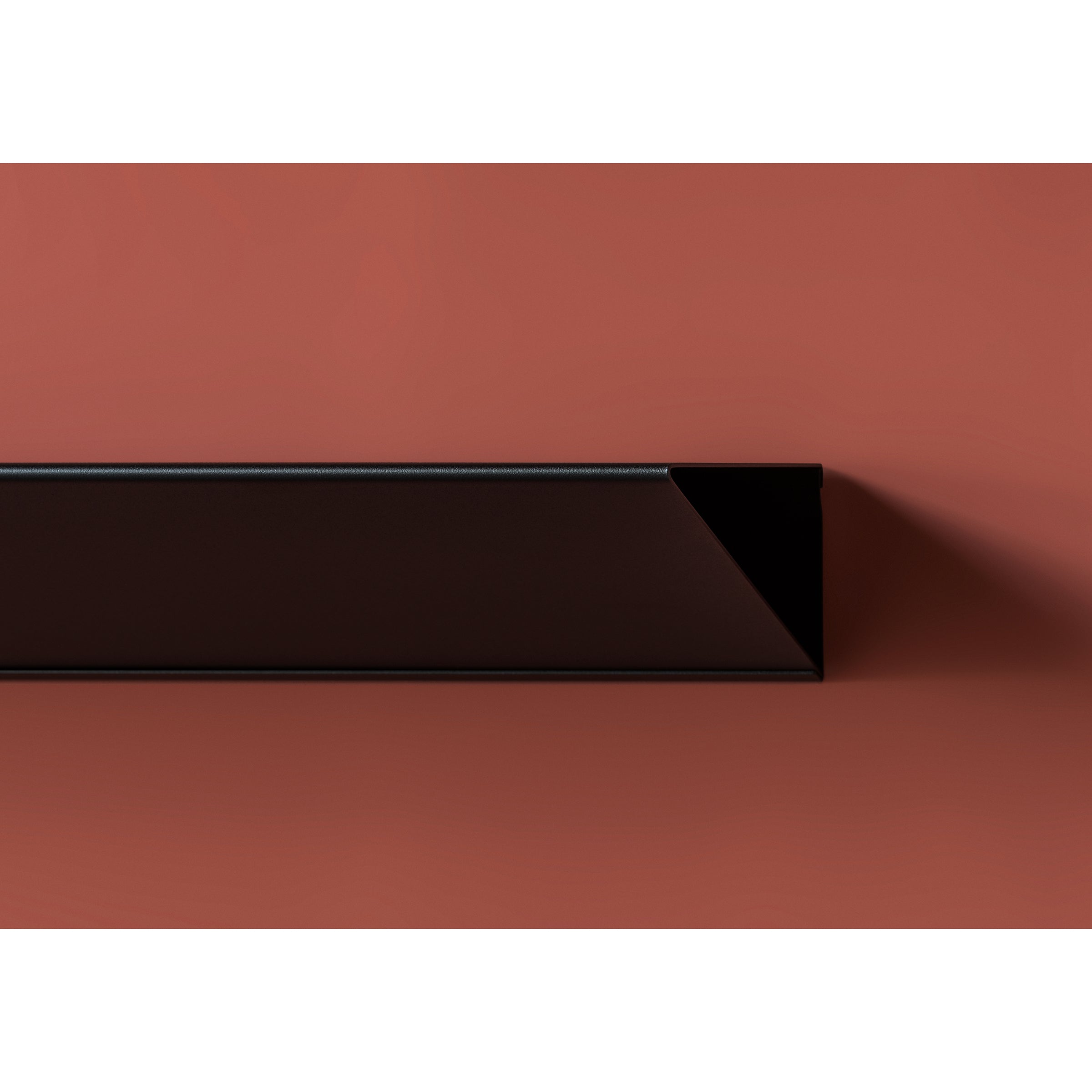 The L1 Newton Shelf by Loehr features minimalist geometric design, showcasing a long narrow black rectangle with a triangular profile on a matte brown background. Crafted from sheet steel, it creates subtle shadows that add depth and contrast to the composition.