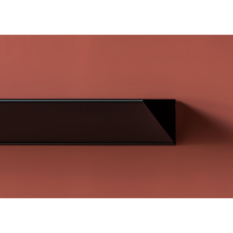 The L1 Newton Shelf by Loehr features minimalist geometric design, showcasing a long narrow black rectangle with a triangular profile on a matte brown background. Crafted from sheet steel, it creates subtle shadows that add depth and contrast to the composition.