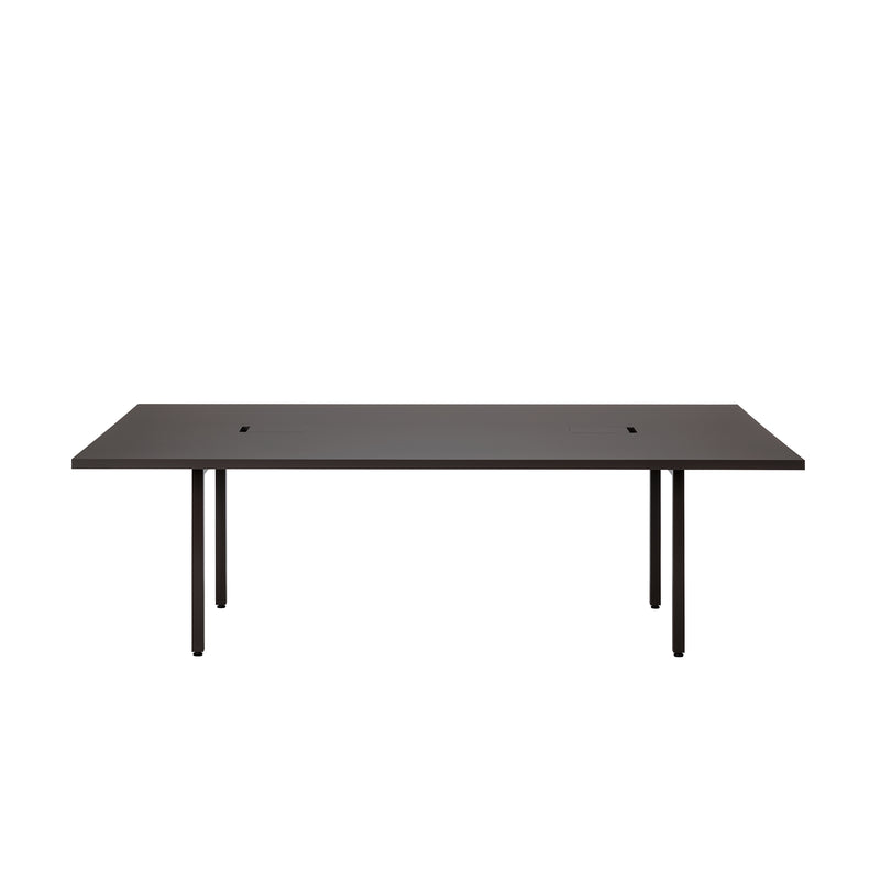 The L2 Eno Worktable by Loehr is a minimalist black table with a rectangular top and slim, straight legs. It features two central slots for cable management, combining functionality and sleek design in a modern hybrid workstation.